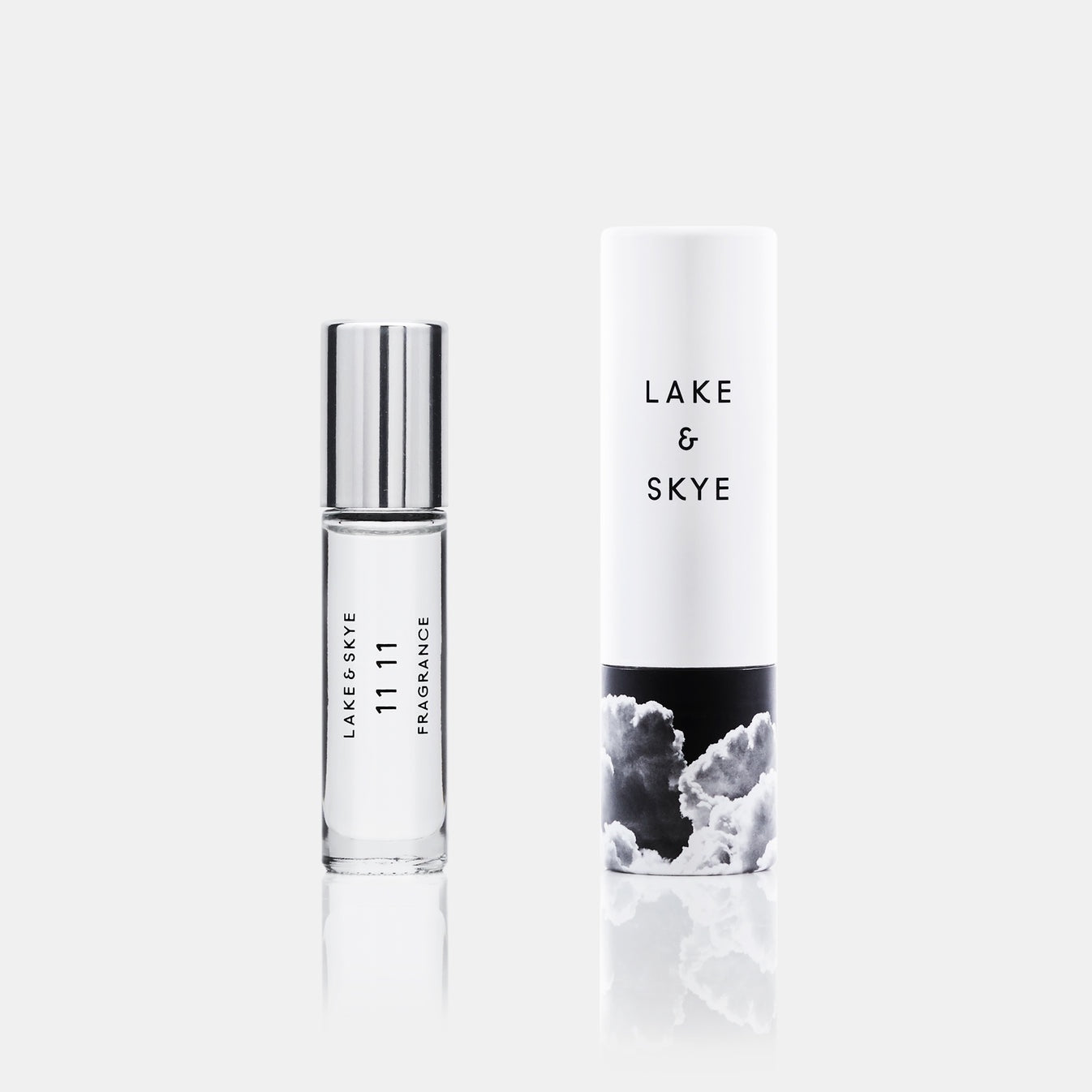 Lake & Skye 11 11 fragrance rollerball with silver cap next to white cylindrical packaging with cloud design