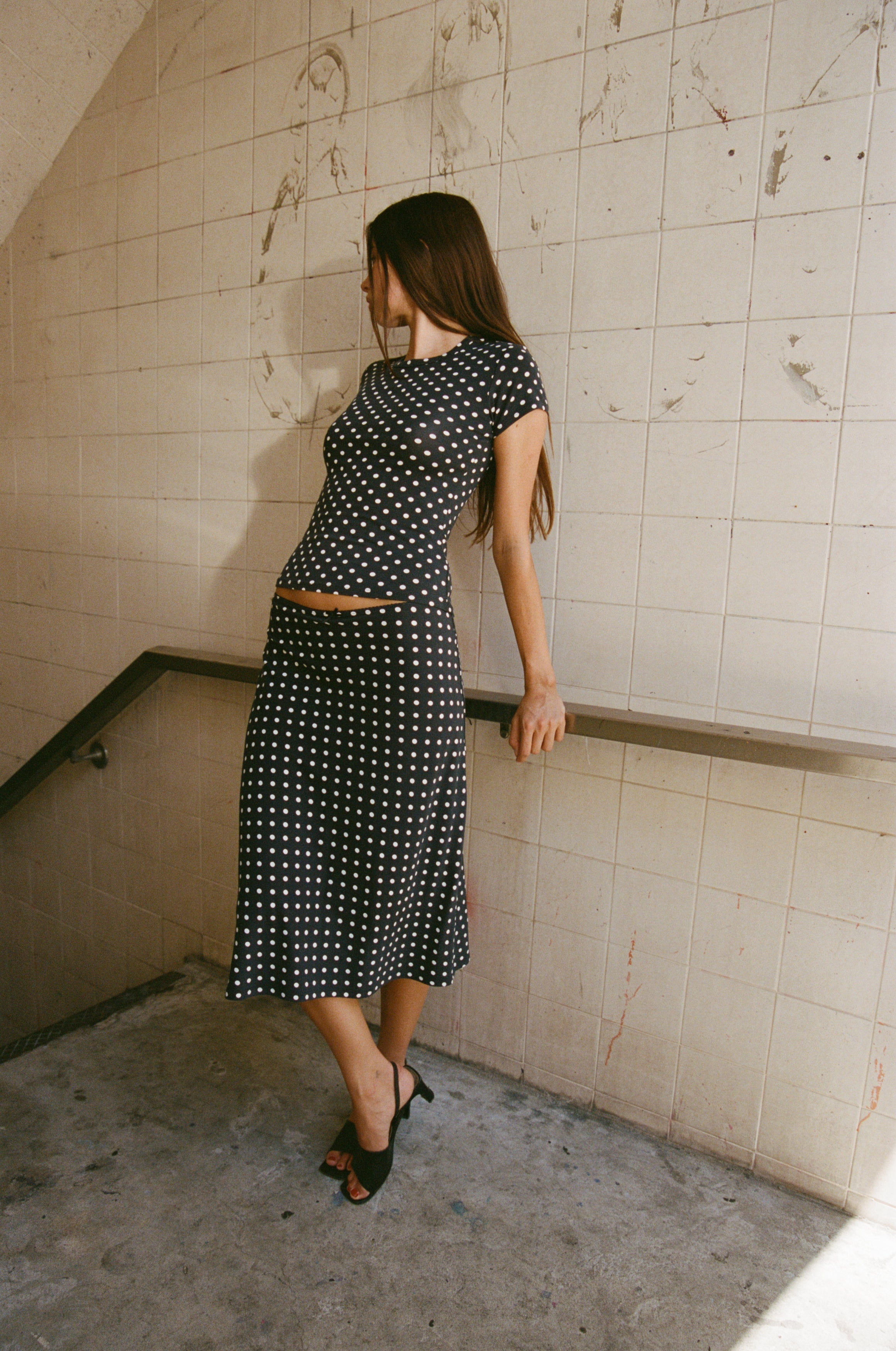 Black and white polka dot two-piece set with cropped top and midi skirt, featuring a vintage-inspired design