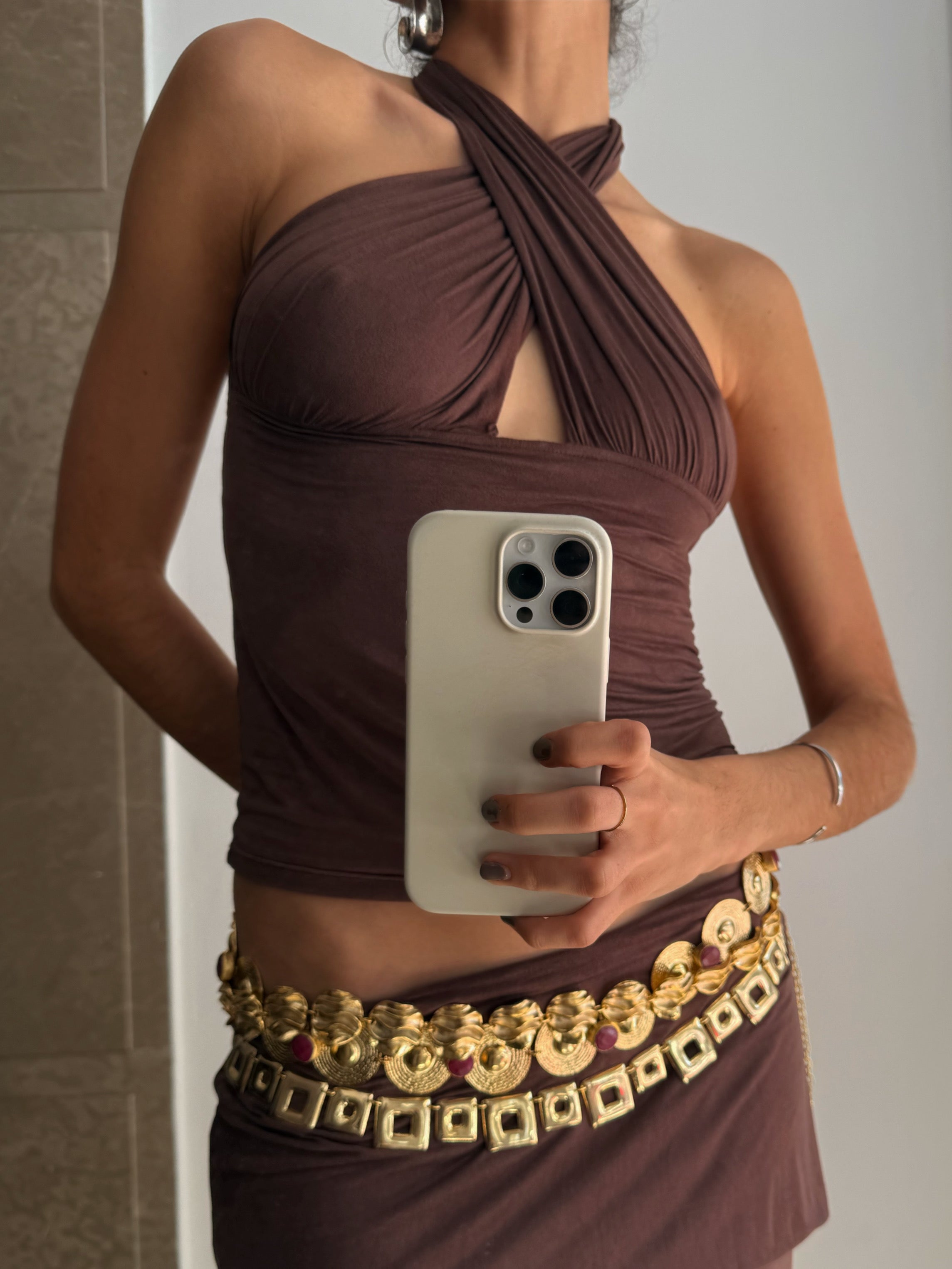 Brown halter neck ruched top with cutout detail and gold embellished coin belt at waist