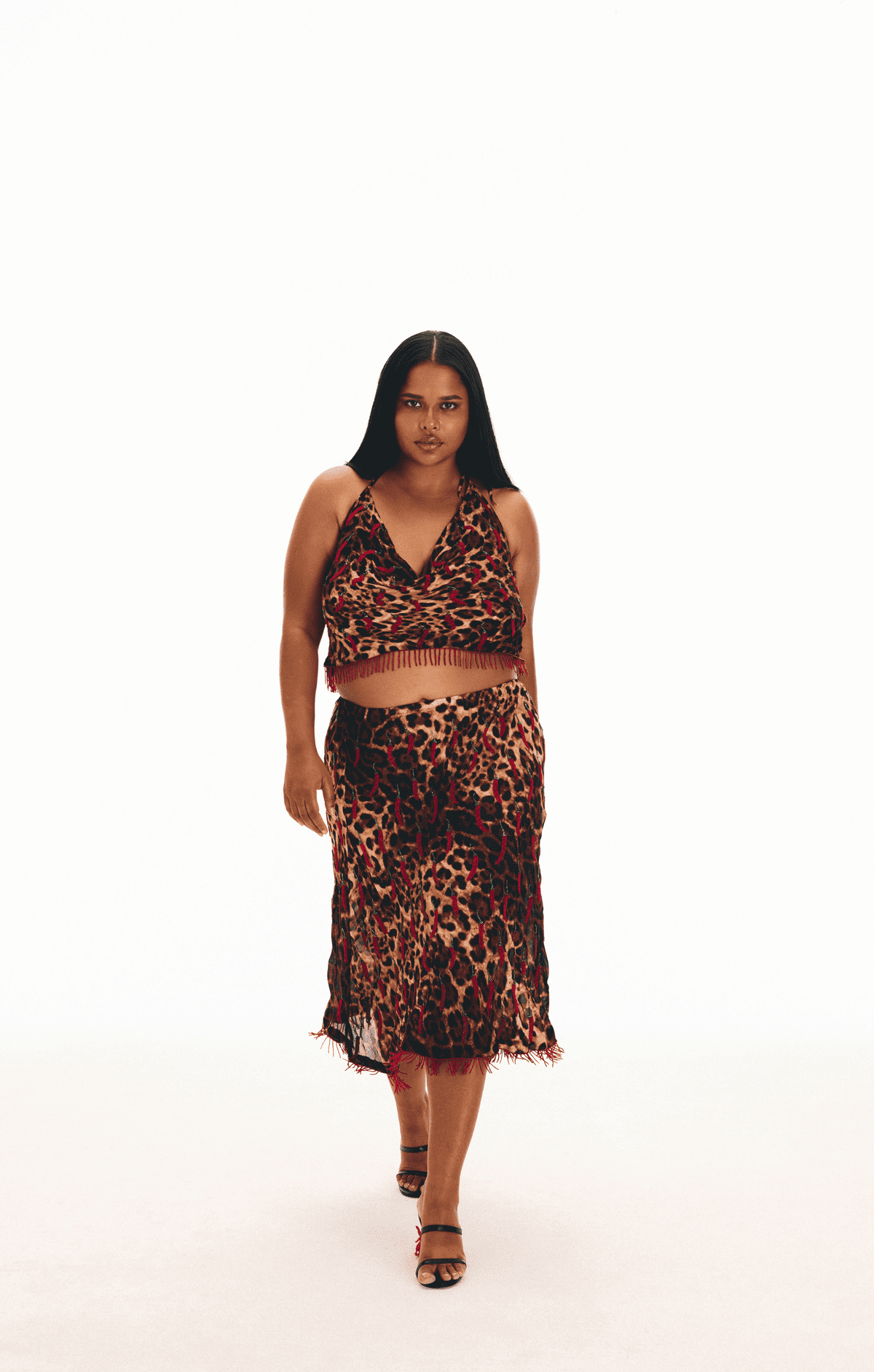 Leopard print two-piece set with halter crop top and midi skirt featuring fringe trim details in red, black and tan