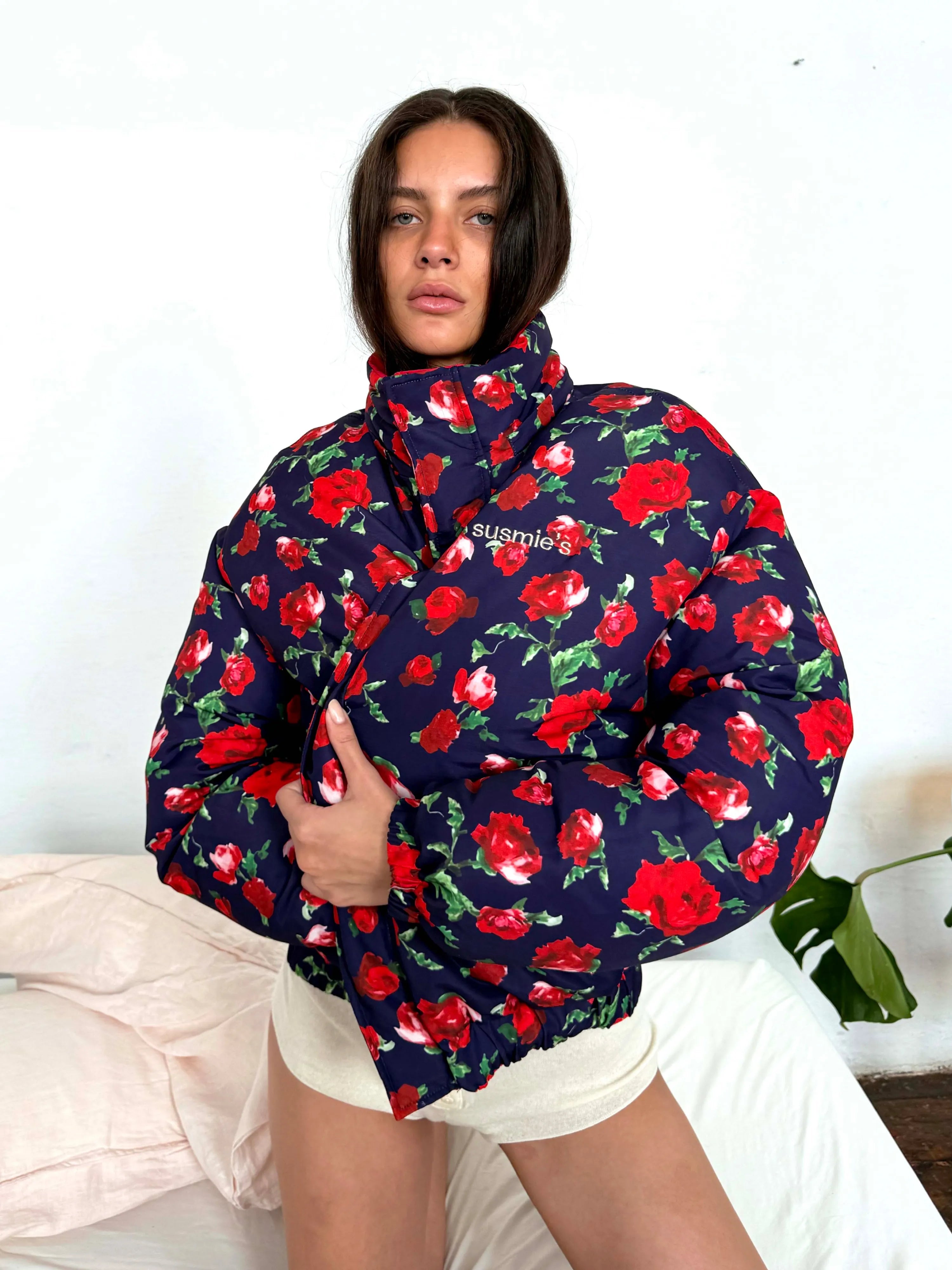 Navy blue puffer jacket with red rose floral print, high collar, oversized fit, embroidered logo on chest