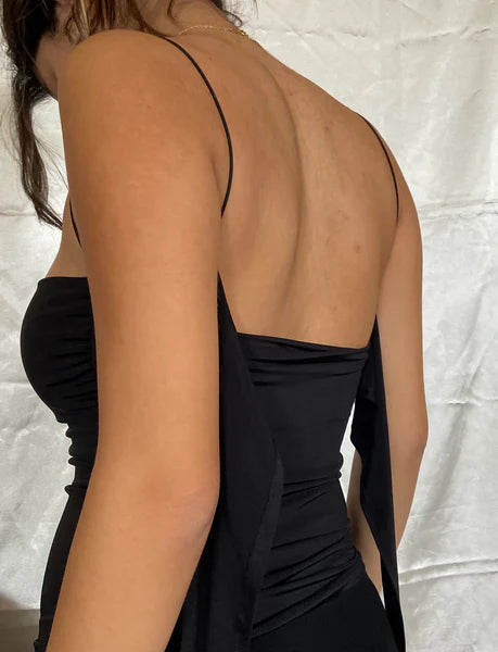 Black dress with open back on a neutral background