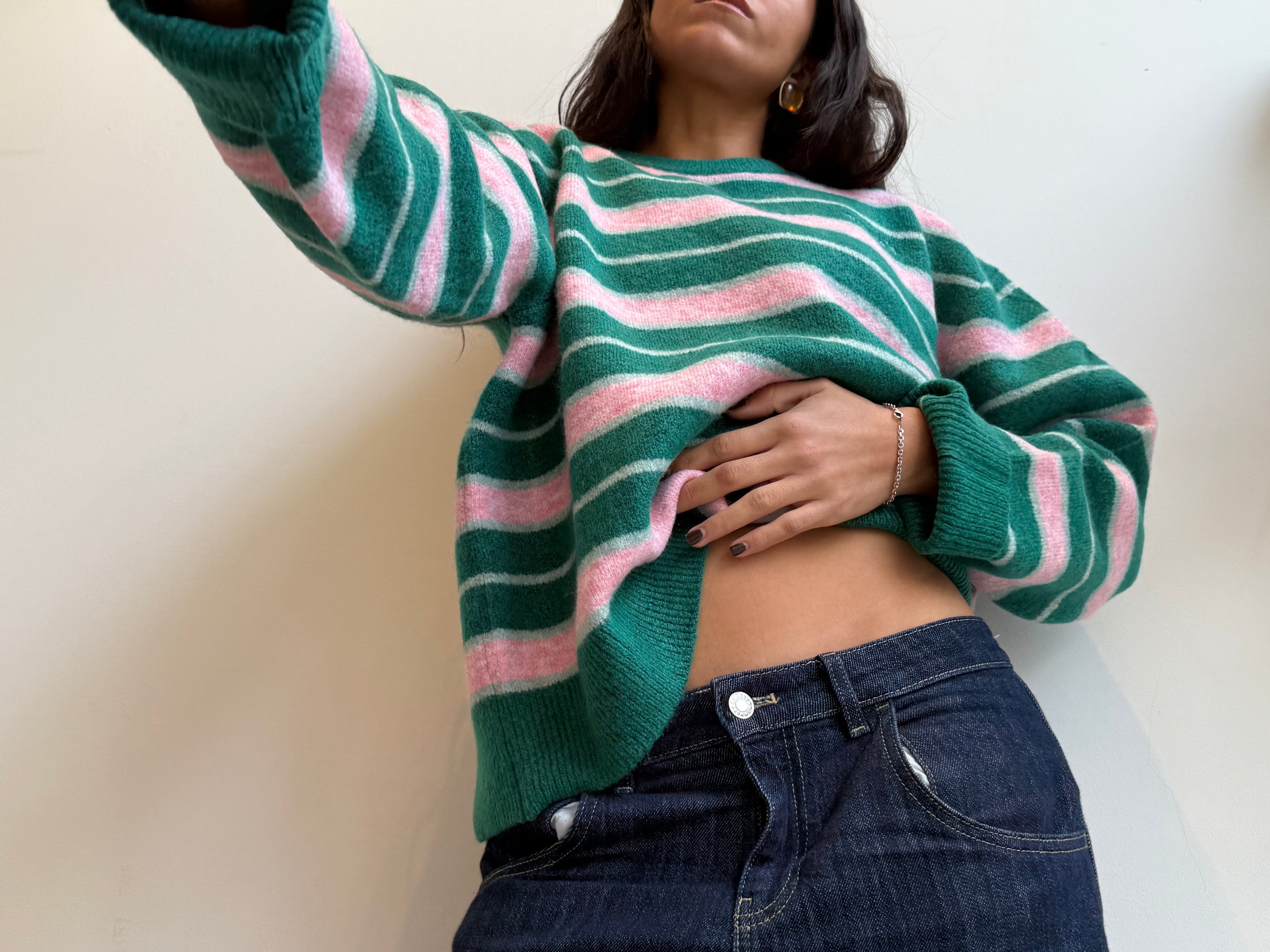 Green and pink striped cropped sweater with balloon sleeves paired with dark denim jeans