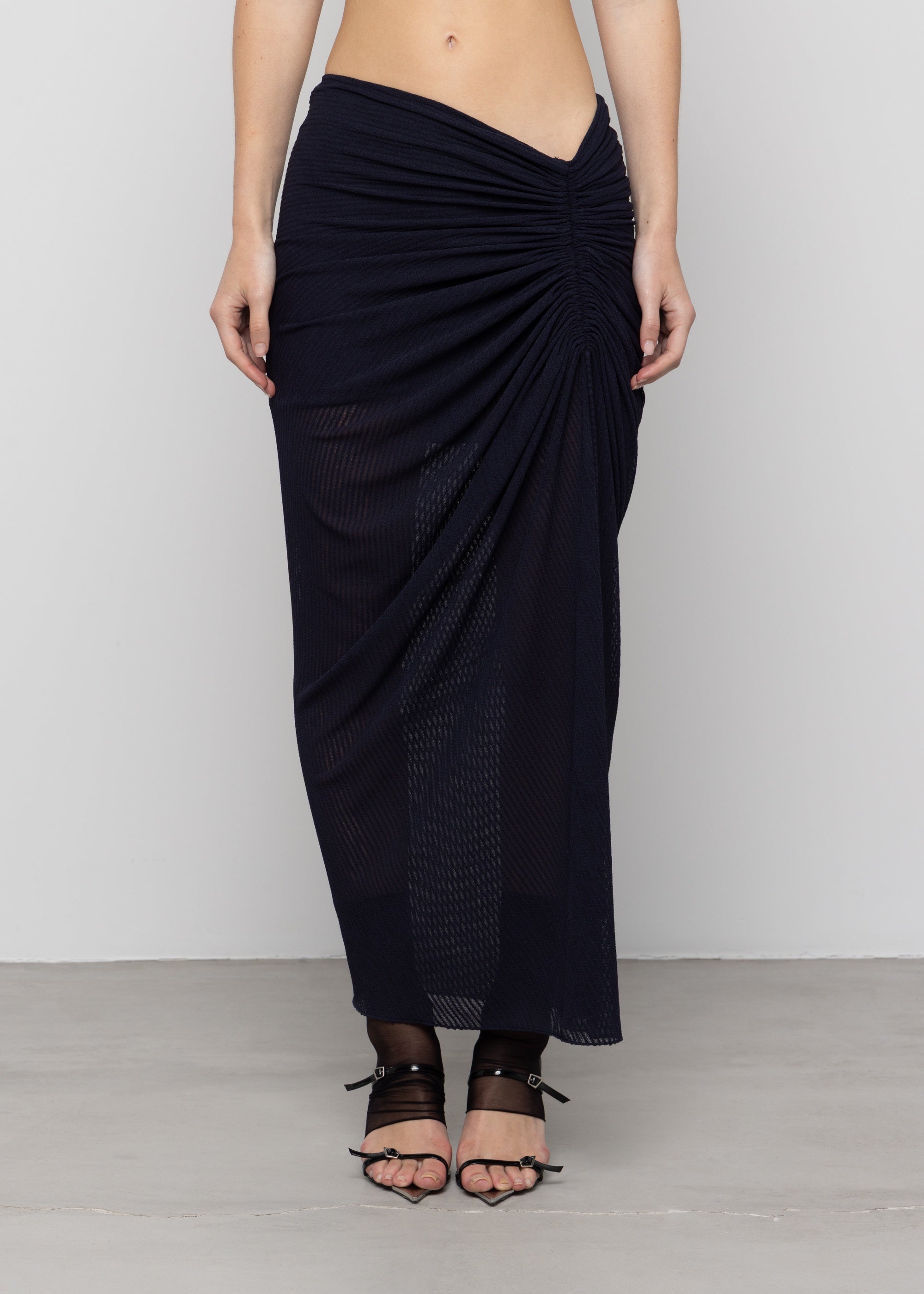 Black mesh maxi skirt with twisted draping detail at hip, semi-sheer fabric, asymmetric gathered design