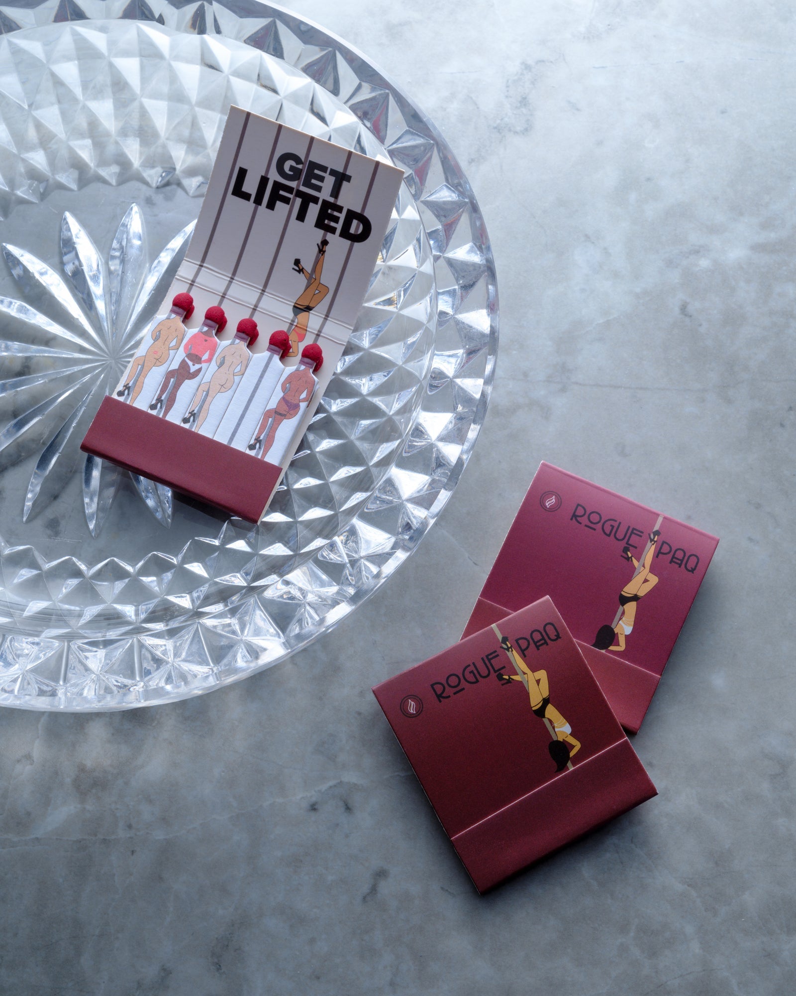 Crystal tray displaying Get Lifted and Rogue Pad beauty products with geometric faceted design on marble surface