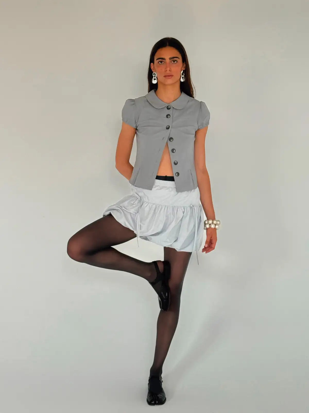 Gray button-front cardigan with Peter Pan collar and puff sleeves, styled with white skirt and black tights