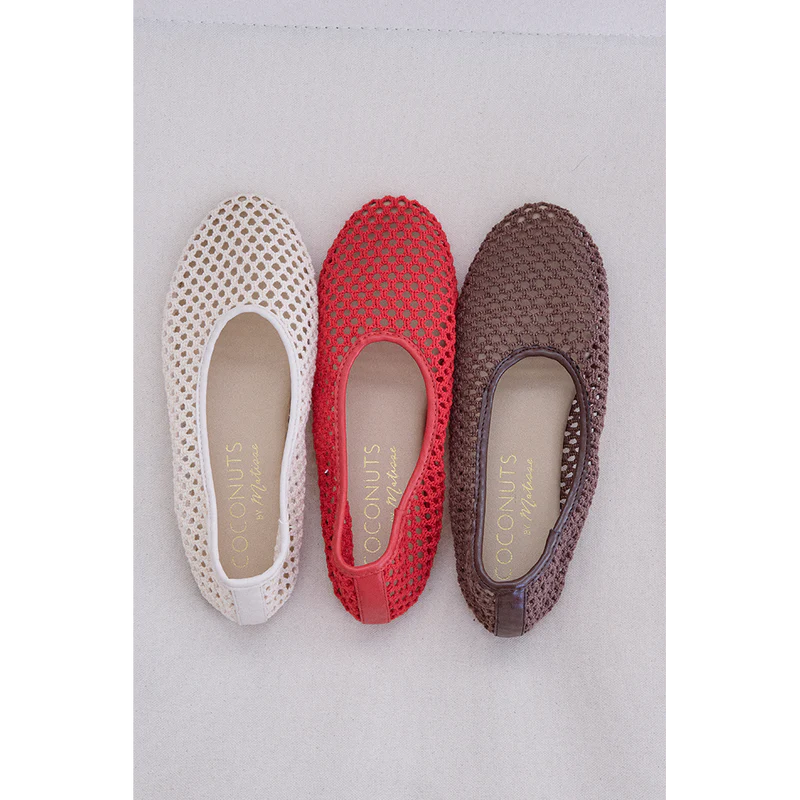 Three perforated mesh ballet flats in white, coral red, and brown with leather accents and cushioned insoles displayed from above