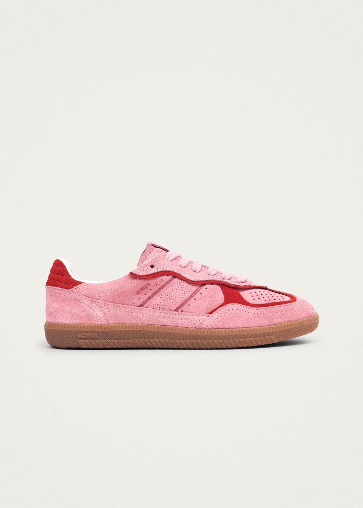 Pink suede sneaker with red contrast panels and gum sole, side view showing lace-up design and perforated details