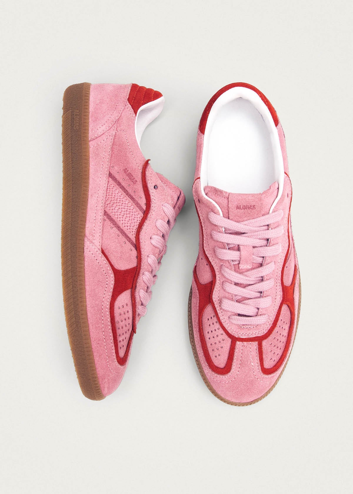 Pink suede sneakers with red flame-like overlays, white lining, and gum sole, displayed from top view