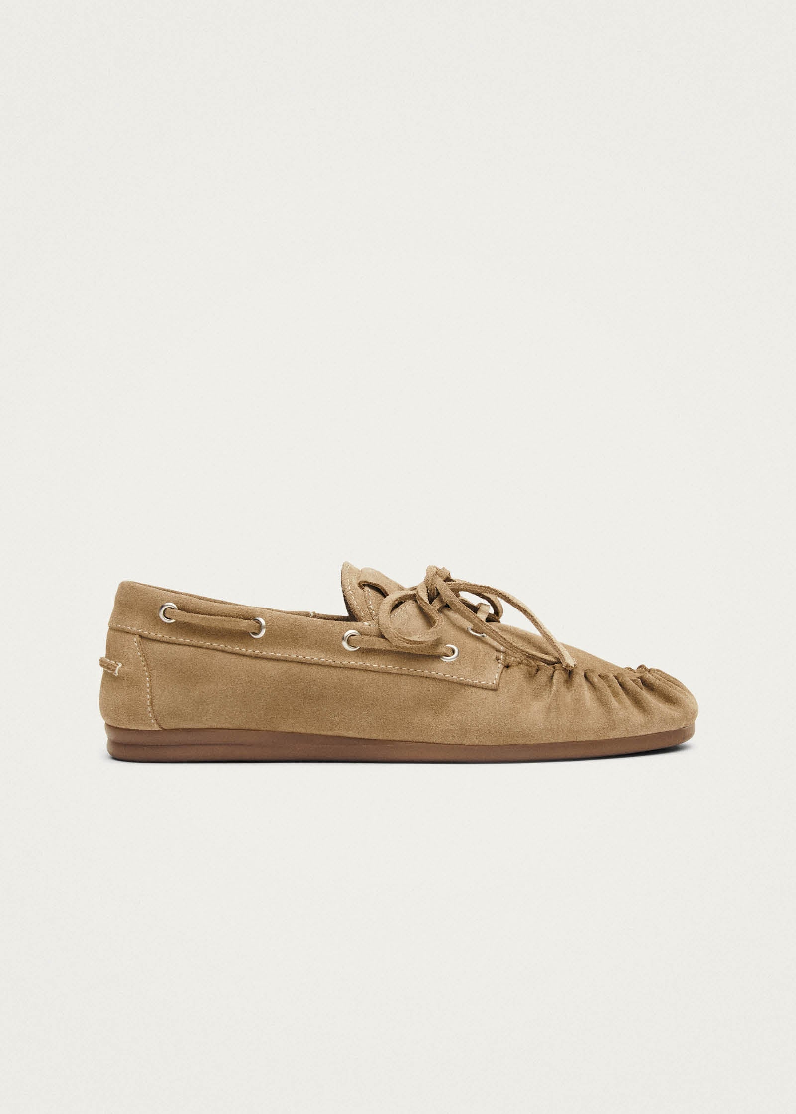 Tan suede moccasin slipper with lace-up detail and brown rubber sole