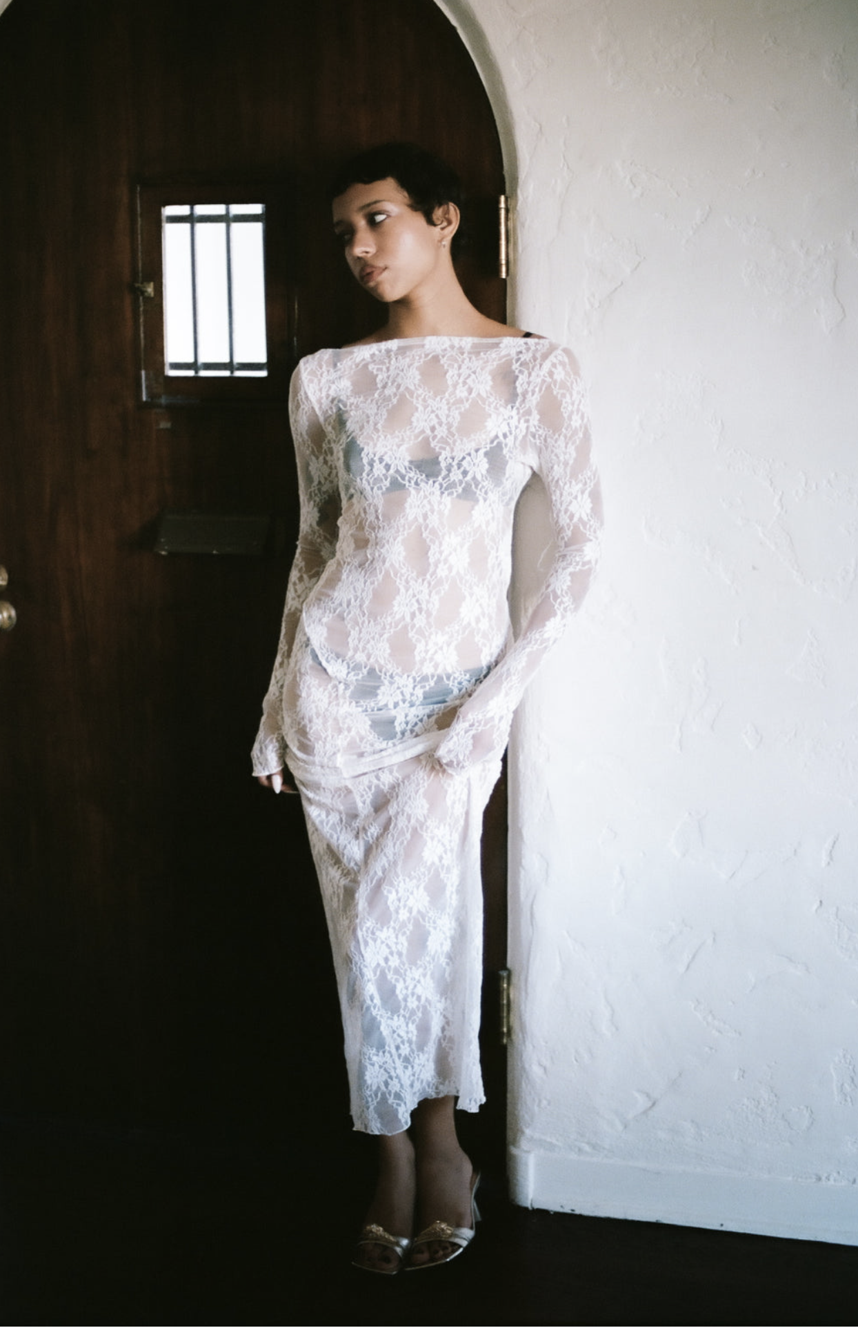 White lace long-sleeve midi dress with sheer overlay and fitted silhouette, featuring delicate floral pattern throughout