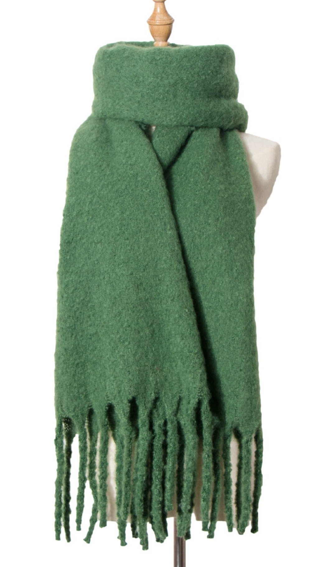 Green wool scarf with fringe detail displayed on mannequin, showing soft textured fabric and long length