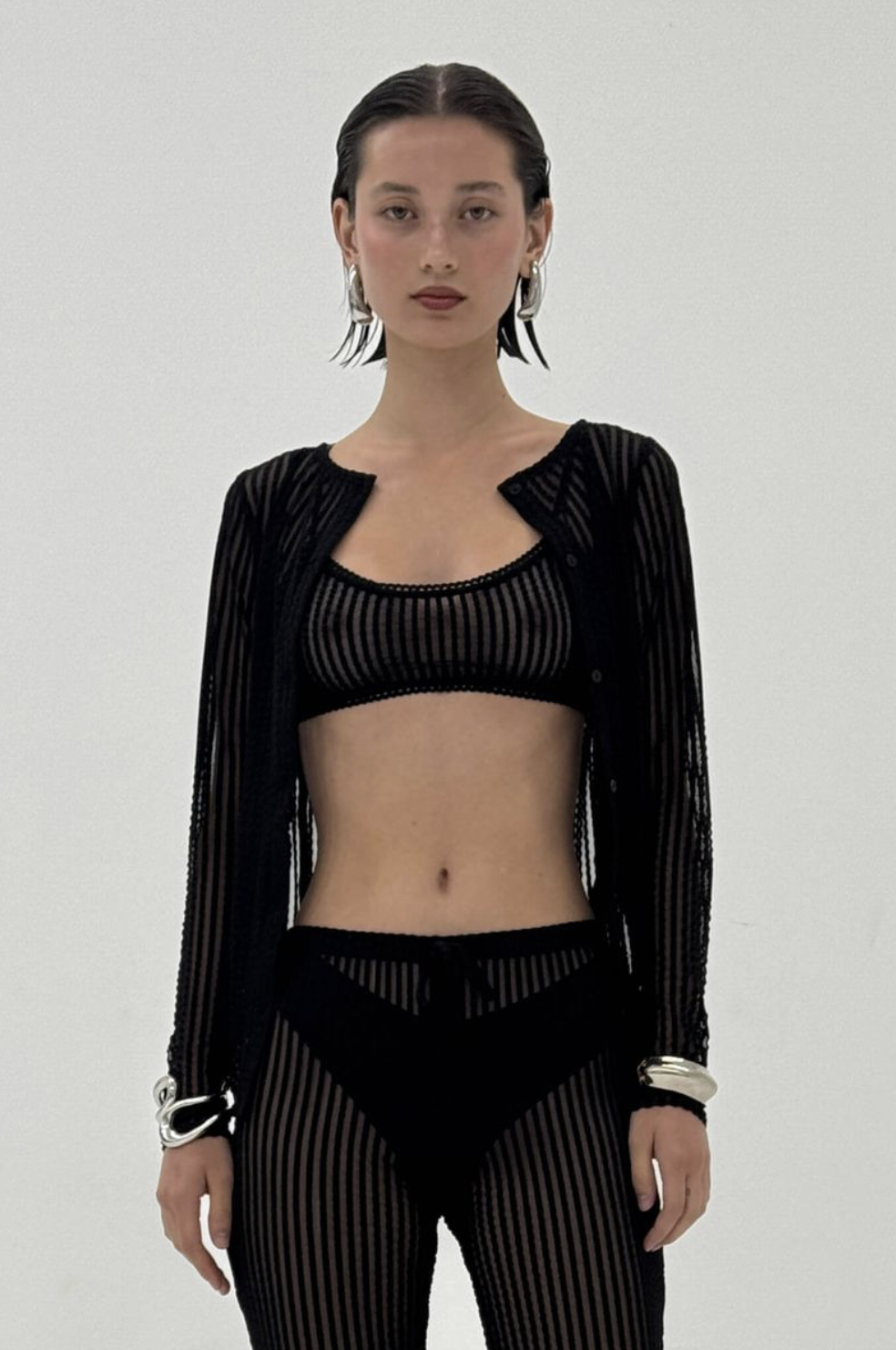 Black sheer striped knit crop top with matching cardigan and pants set featuring transparent ribbed fabric and long sleeves