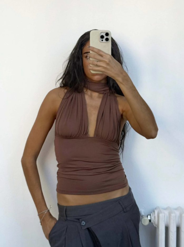Brown halter neck wrap top with ruched waist detail and plunging neckline, worn with black trousers