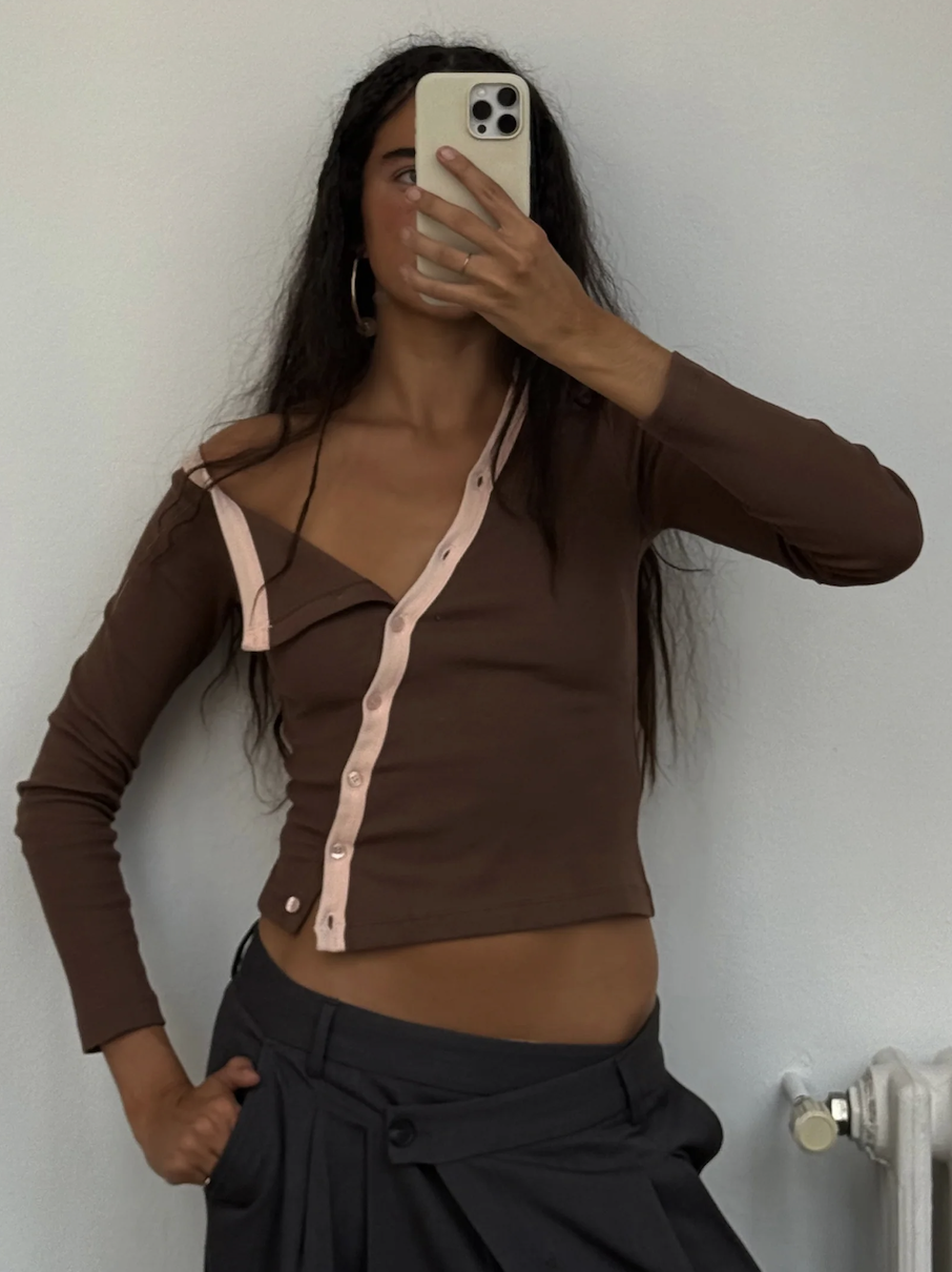 Brown cardigan with pink contrast trim and button closure, long sleeves, fitted crop style