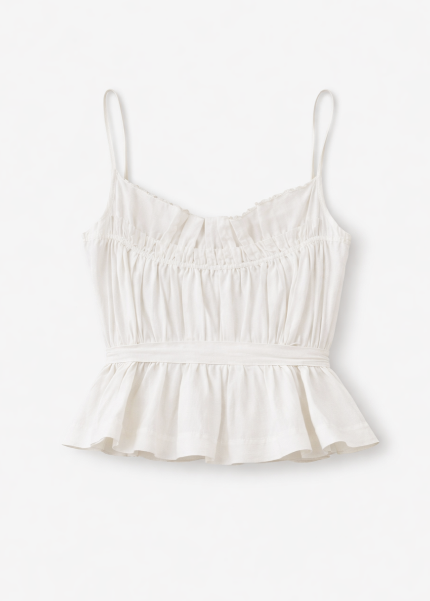 White cotton camisole top with ruched bodice, adjustable straps, and peplum hem detail