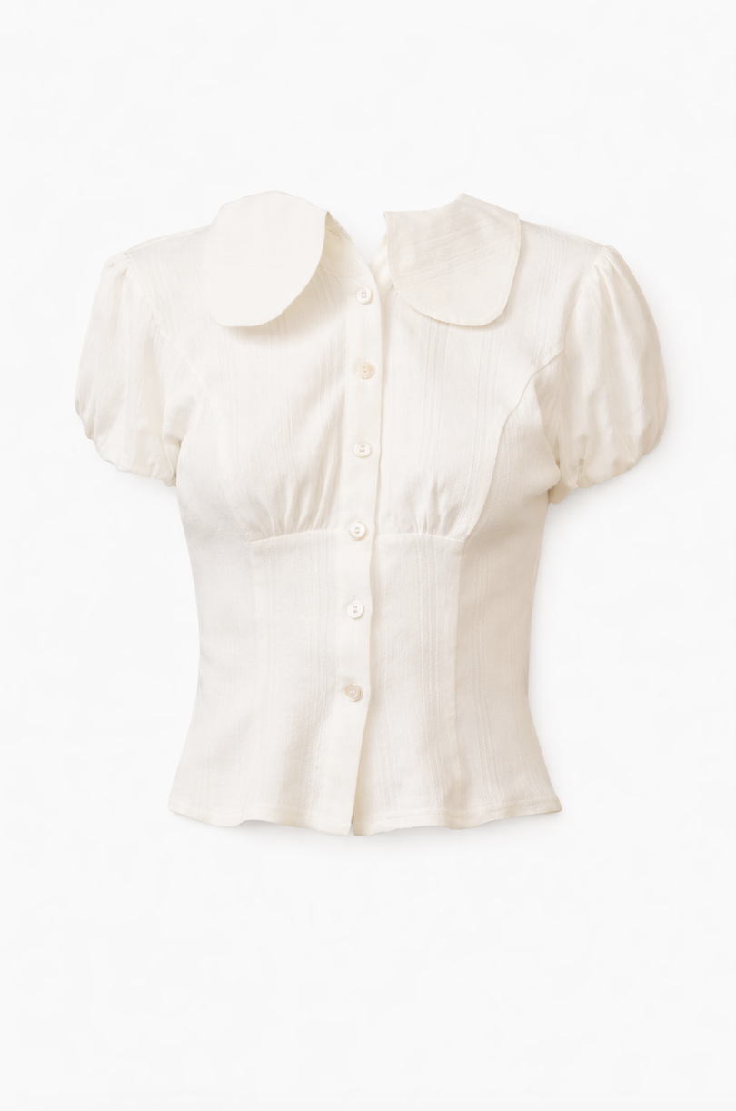White linen button-front blouse with Peter Pan collar and puff sleeves featuring pintuck details and fitted waist
