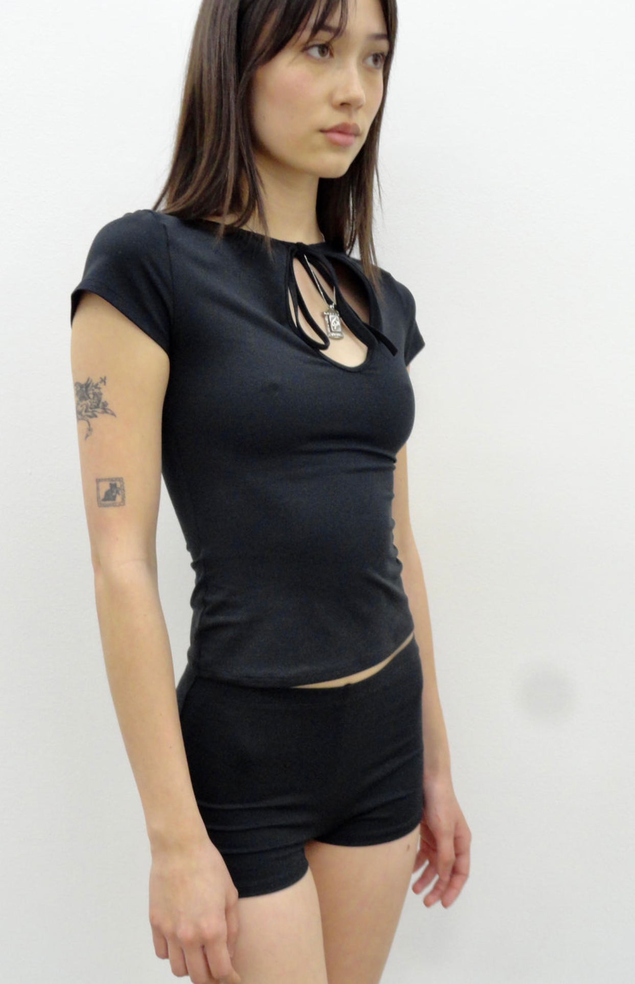 Black fitted t-shirt with keyhole cutout neckline and tie detail, short sleeves, stretchy cotton material