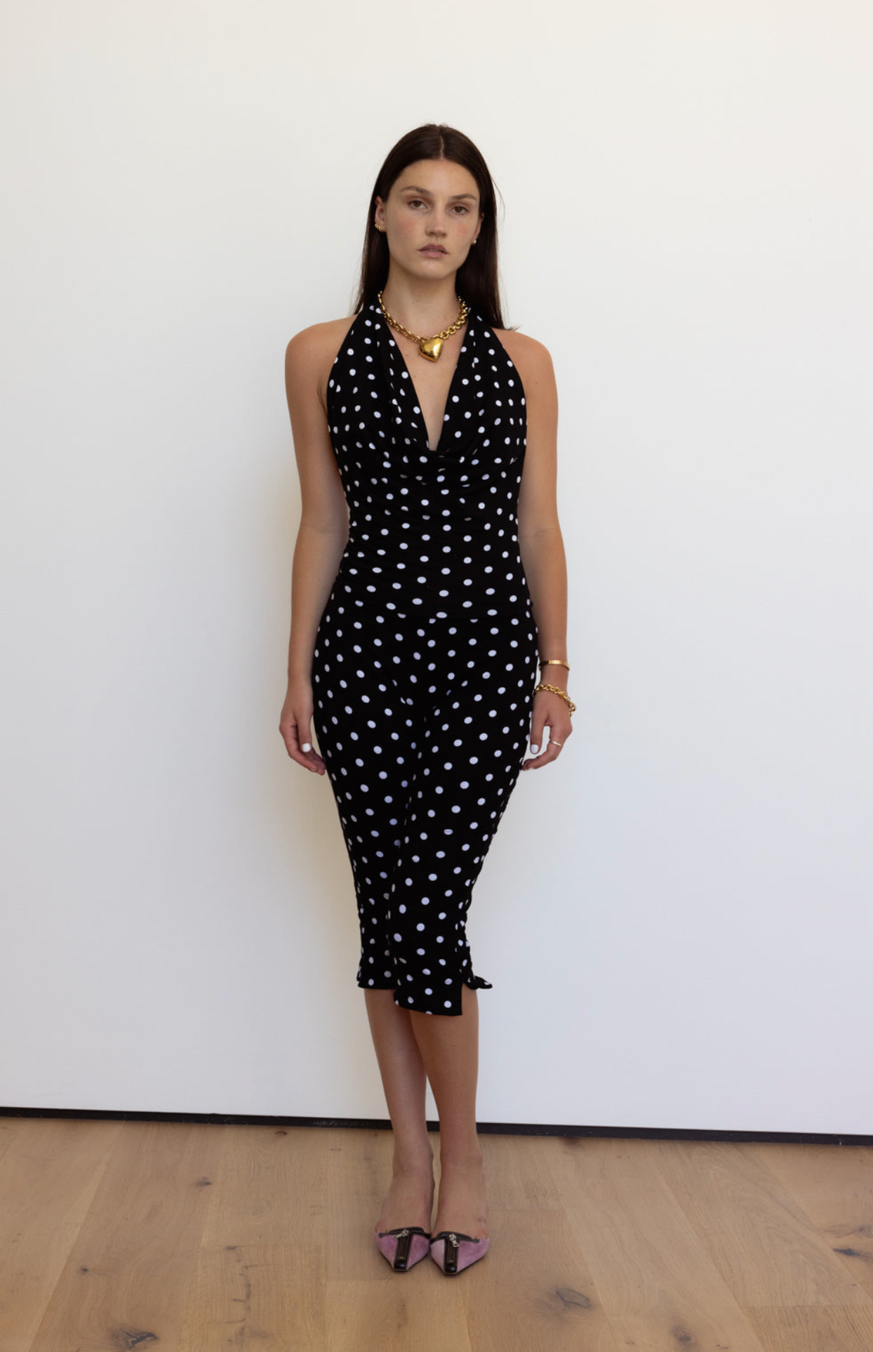 Black and white polka dot halter midi dress with deep V-neckline and ruffle hem detail