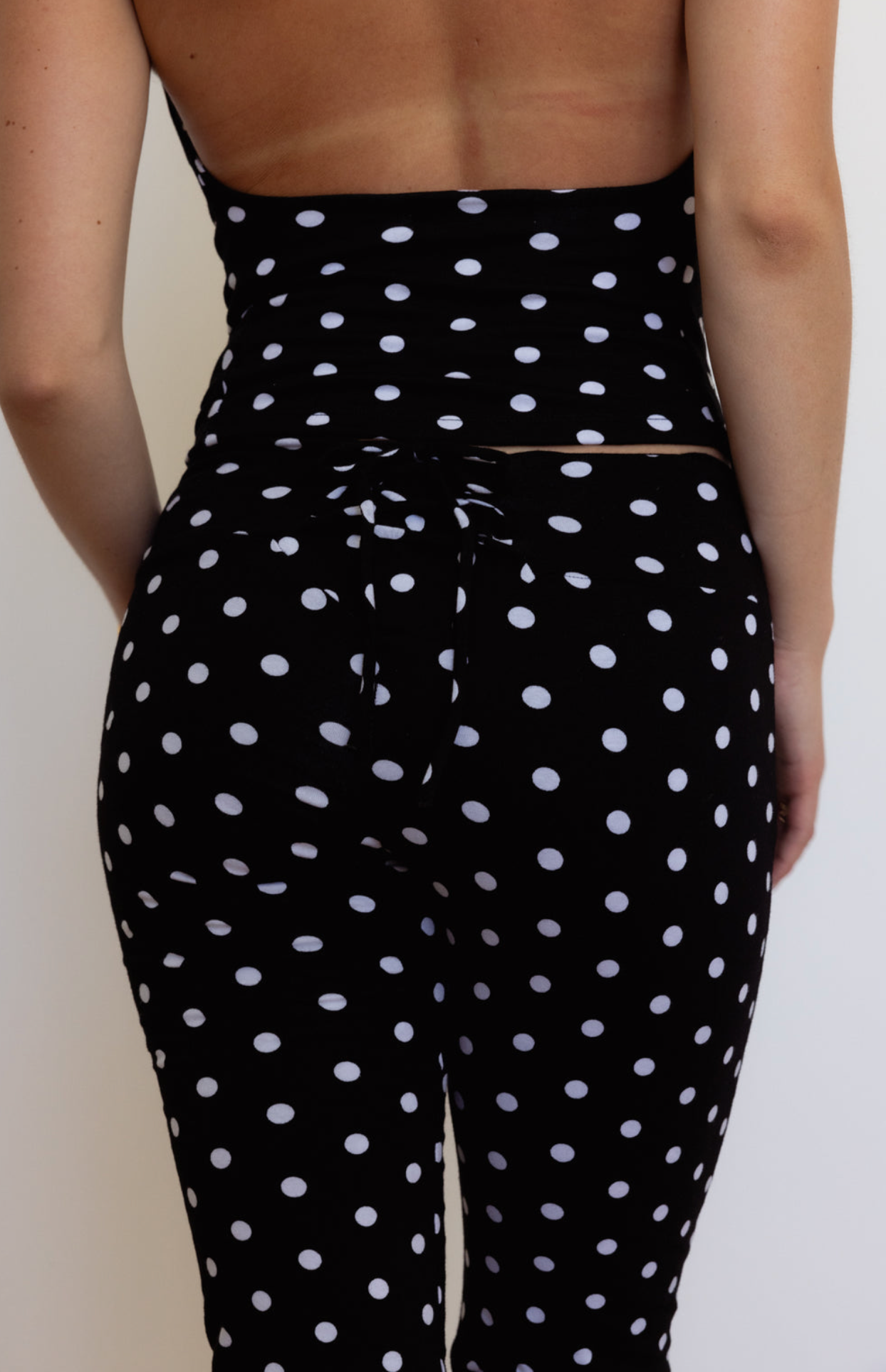 Black polka dot matching set with white spots, featuring high-waisted leggings and crop top, two-piece activewear outfit