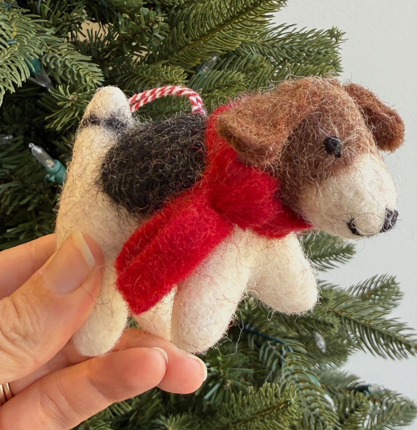 Handmade felt dachshund dog Christmas ornament with brown and white coloring, red scarf, and striped hanging loop