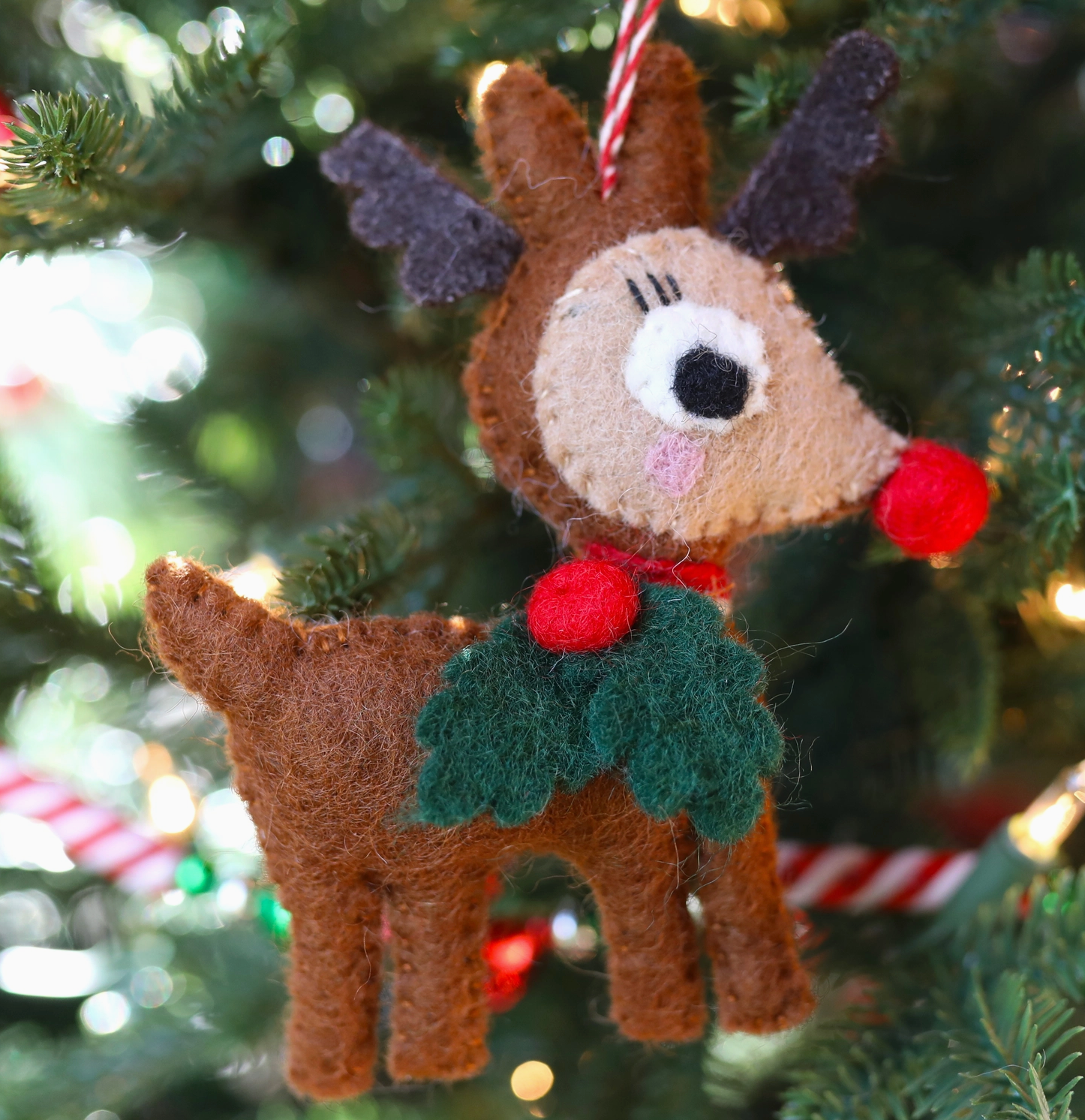 Handmade brown felt reindeer Christmas ornament with gray antlers, red pom-pom nose, and green holly collar decoration