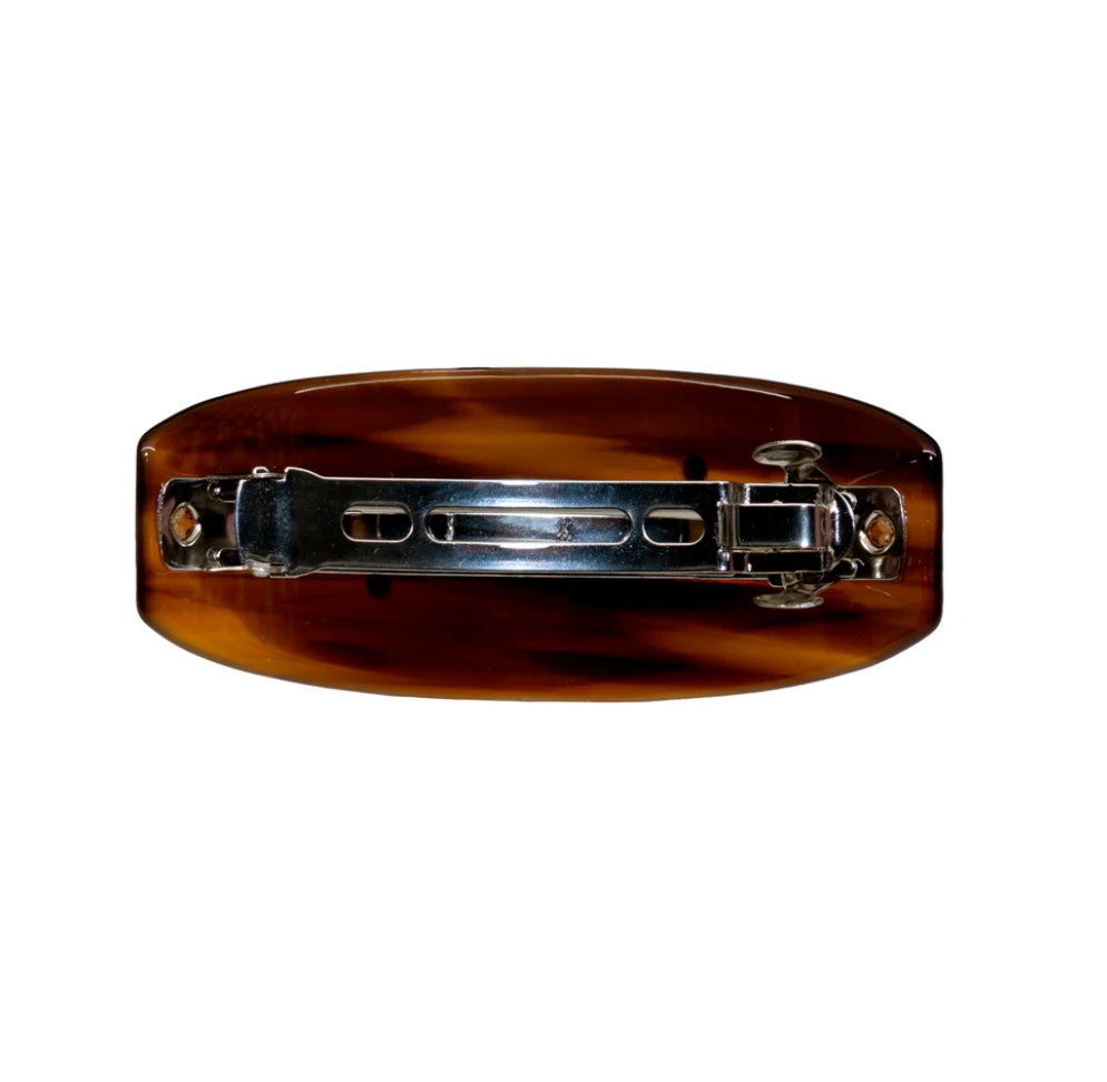 Tortoiseshell brown hair barrette clip with silver metal clasp mechanism, oval shaped accessory shown from back view