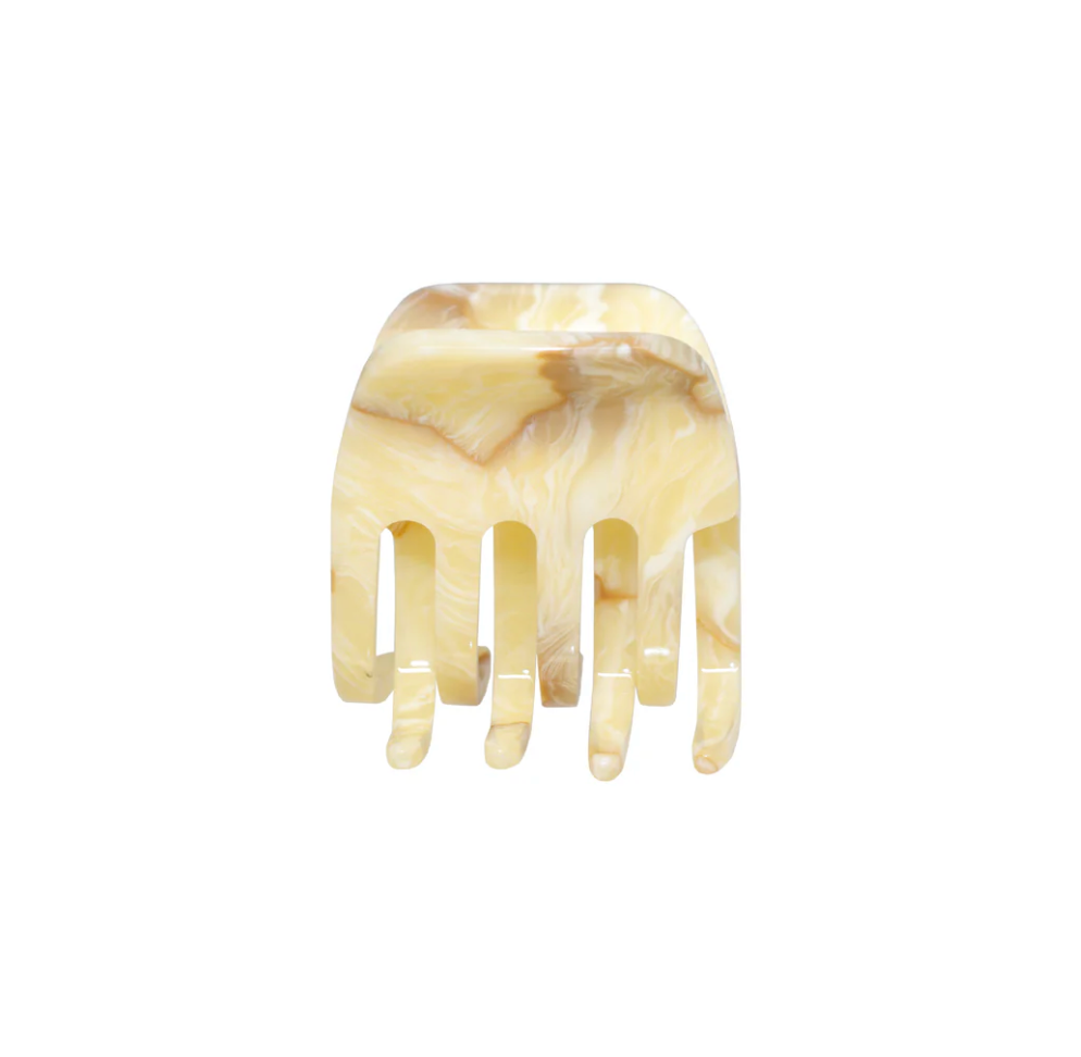 Beige marbled resin hair claw clip with four teeth and curved shape against white background