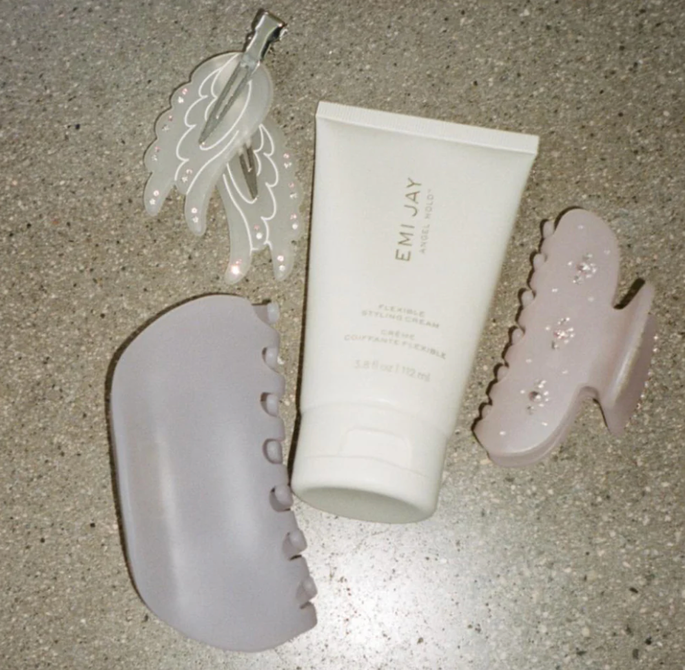 EMI JAY spa set with white tube cream and three pink quartz gua sha massage tools on speckled surface