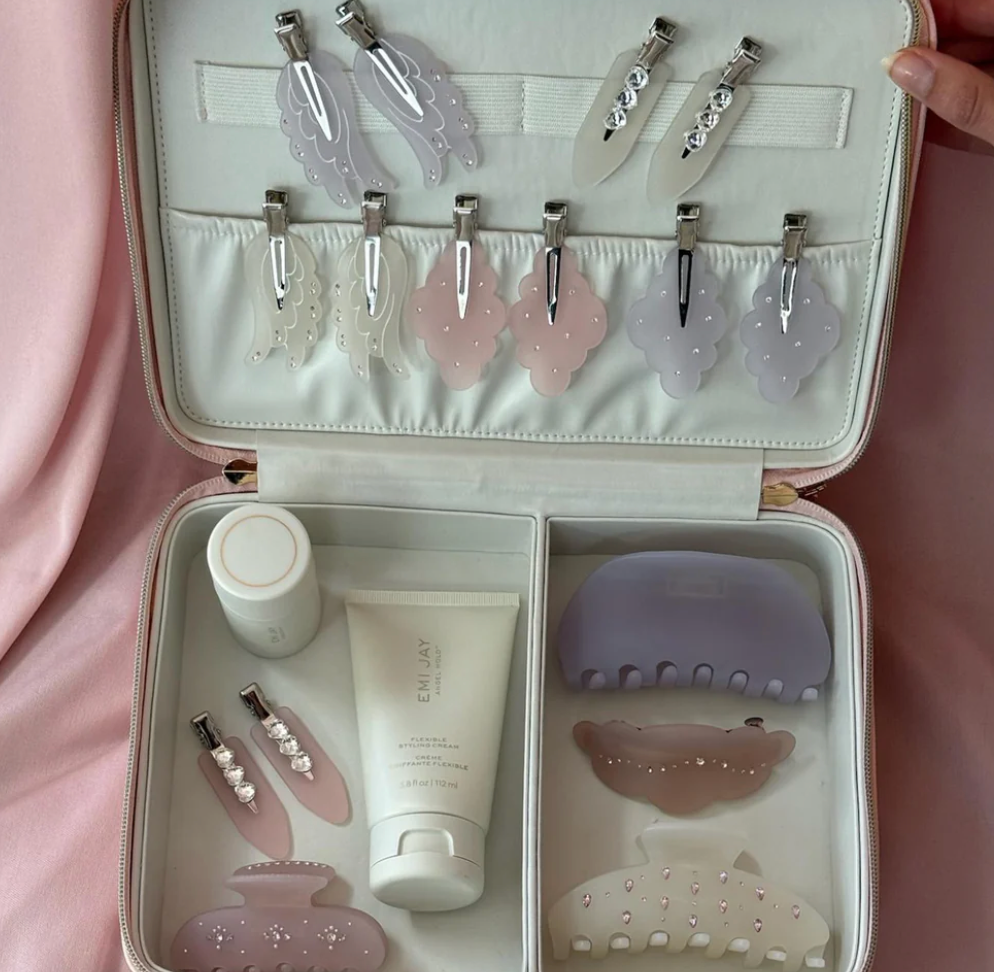 Pink travel case with gua sha tools, facial rollers, and skincare products in organized compartments