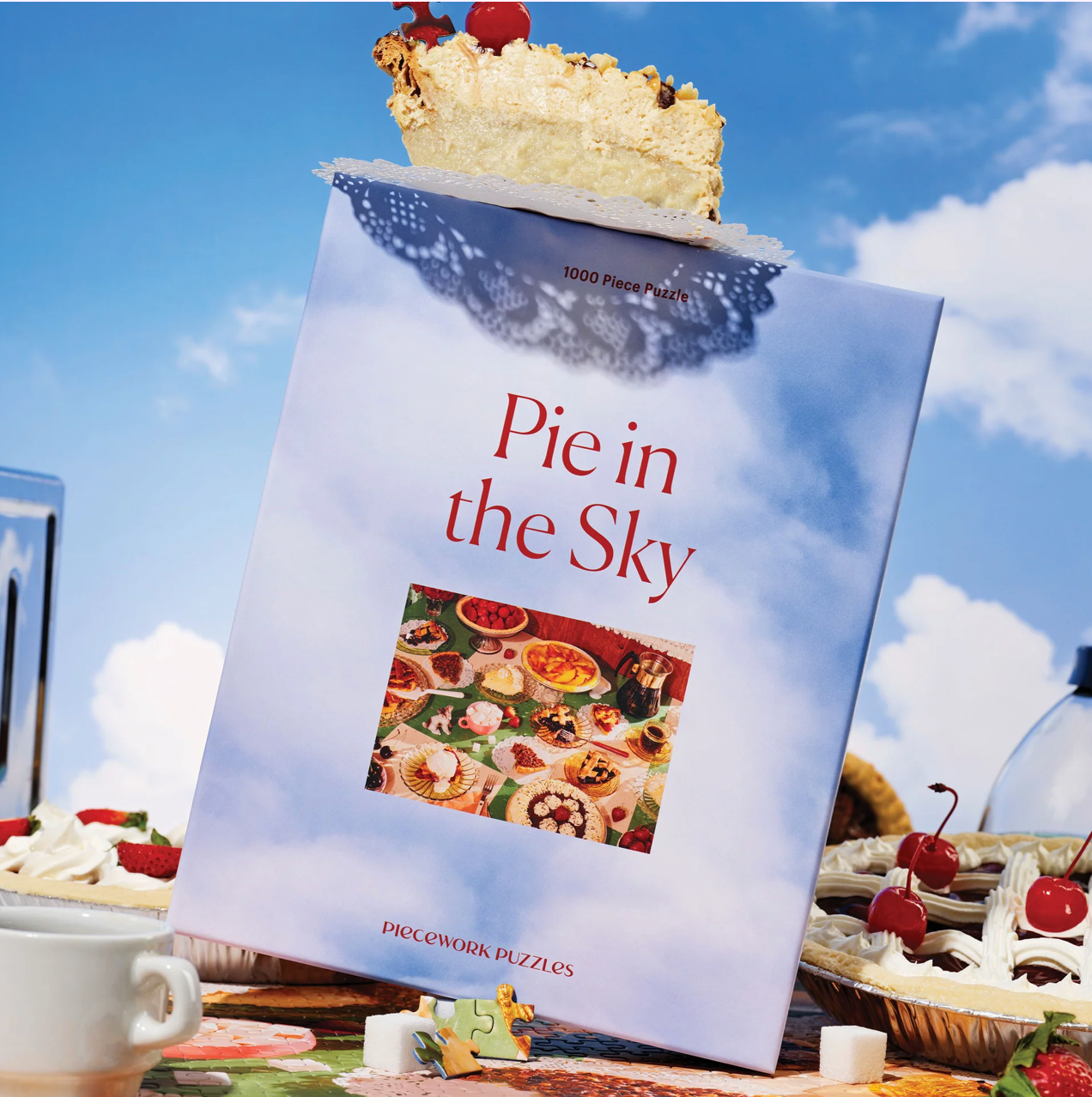 Pie in the Sky 1000-piece jigsaw puzzle box with dessert theme, featuring blue cloudy sky background and colorful pie images