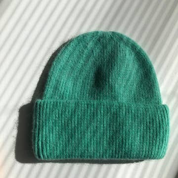 Teal green ribbed knit beanie hat with folded cuff, made from soft fuzzy wool-blend fabric