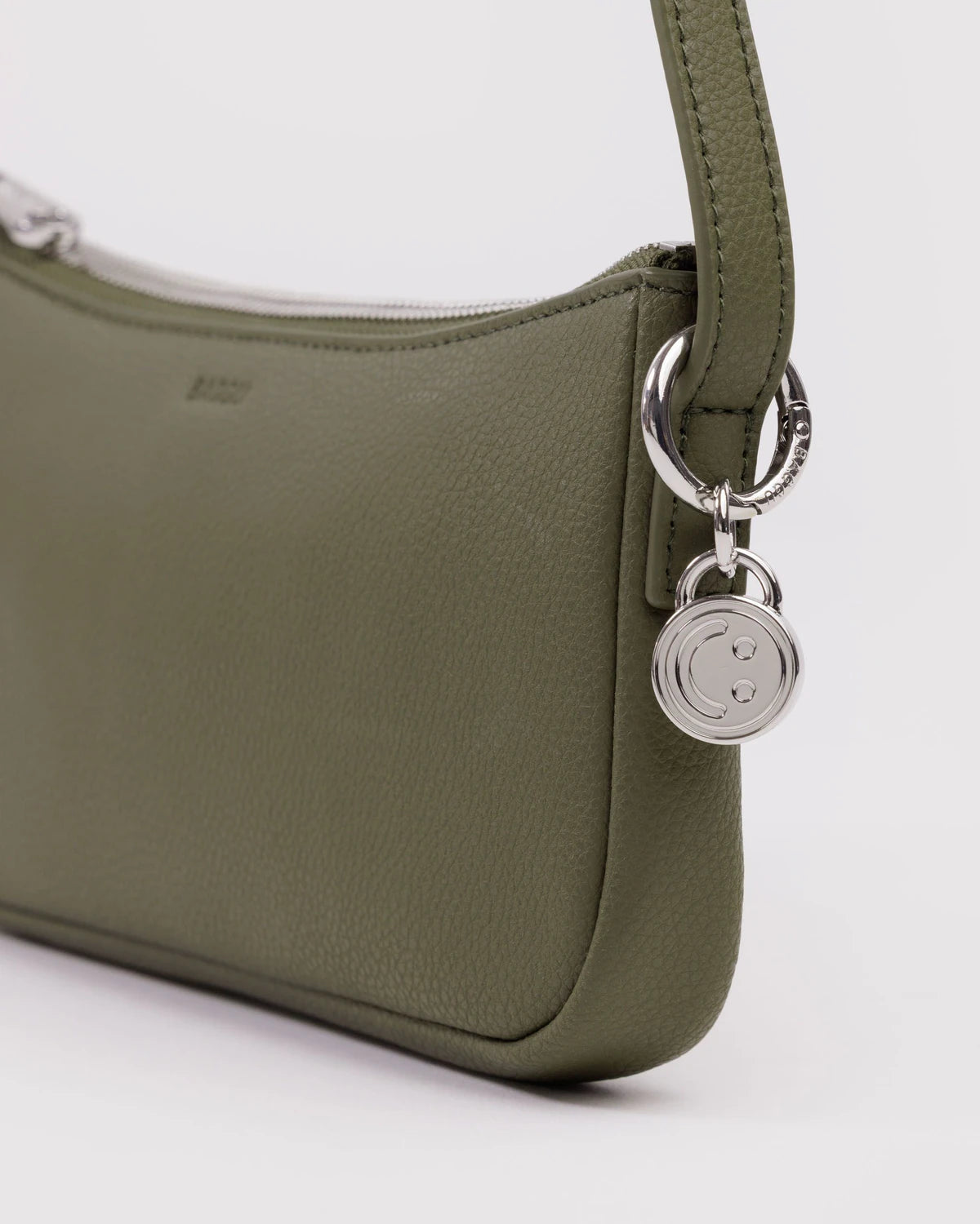 Olive green leather shoulder bag with silver hardware and smiley face charm detail