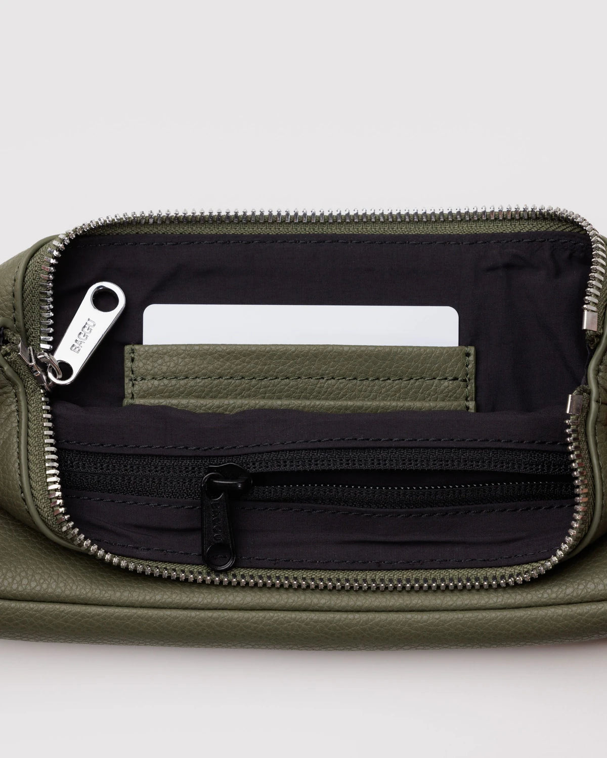 Open olive green leather wallet showing black interior with card slot, white card insert, and zippered compartment
