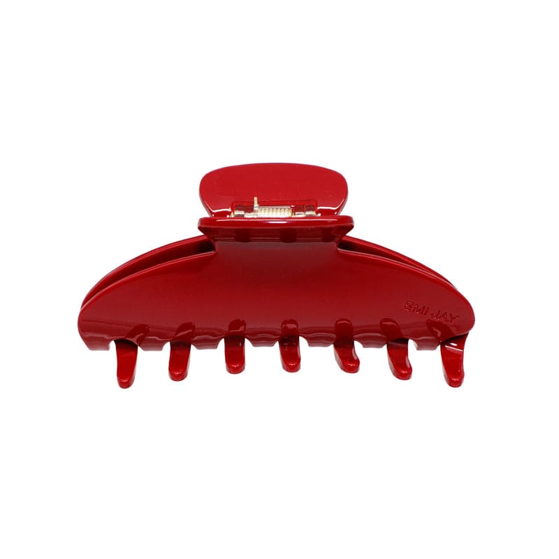Red plastic hair claw clip with curved design and multiple teeth, shown open from side angle
