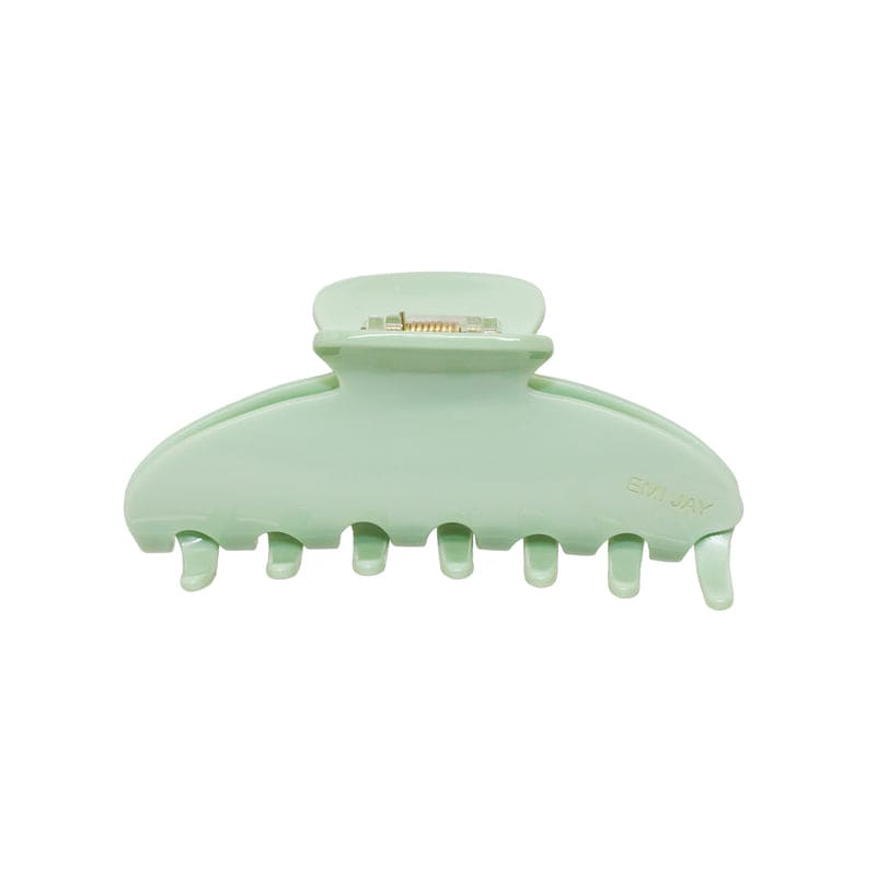 Mint green plastic hair claw clip with curved design and metal clasp mechanism, featuring seven teeth for secure hold