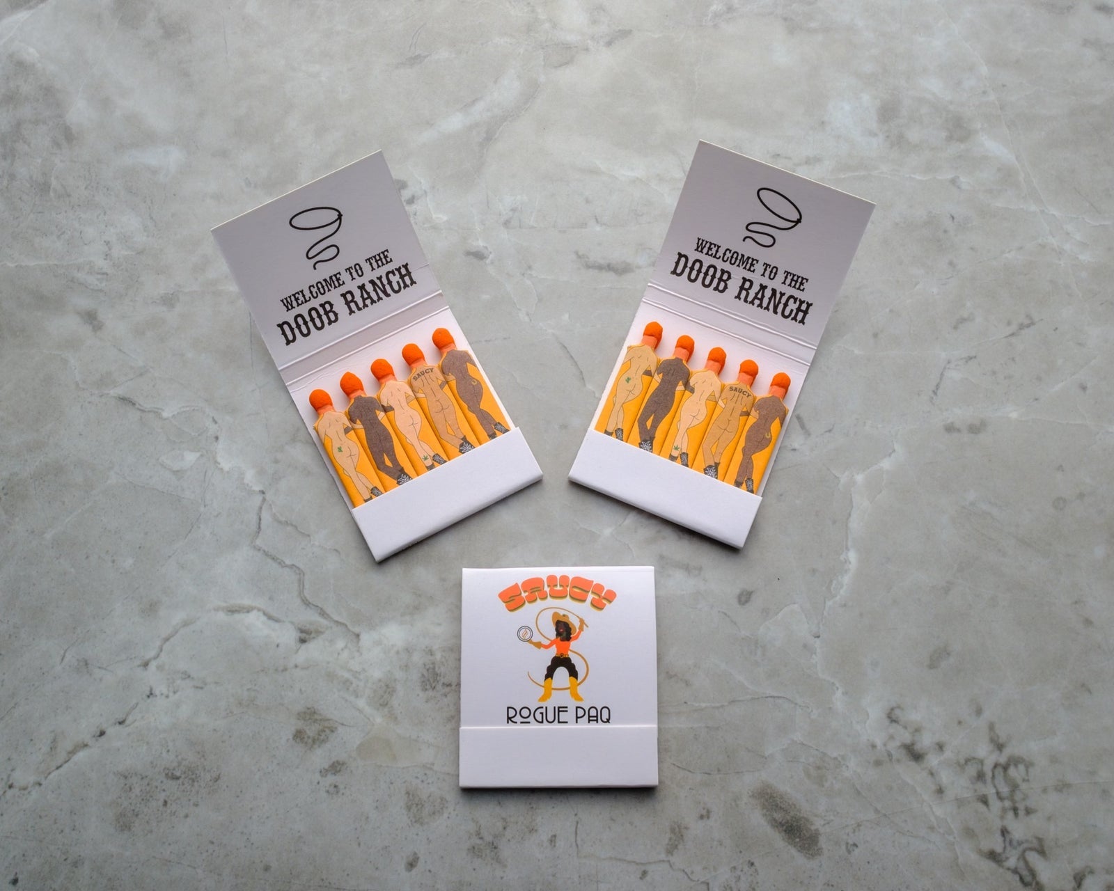 Custom matchbooks with retro Western and 70s designs, featuring orange-tipped matches and white covers with vintage-style graphics