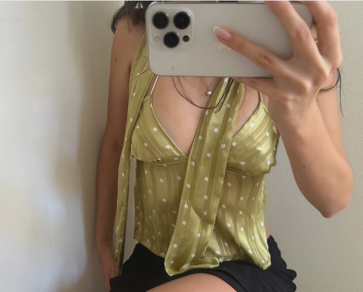 Chartreuse green polka dot cami top with V-neck and delicate straps, shown in mirror selfie with black shorts