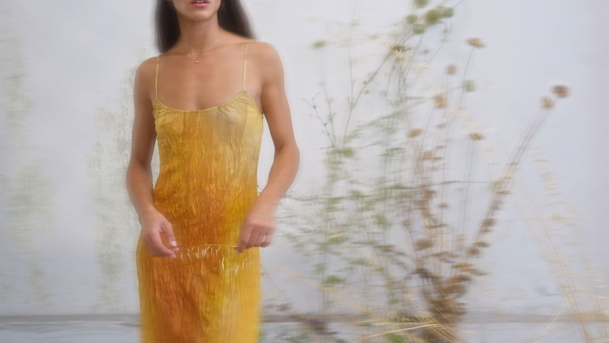 Yellow ombre crinkled silk slip dress with spaghetti straps, gradient from gold to amber, midi length.