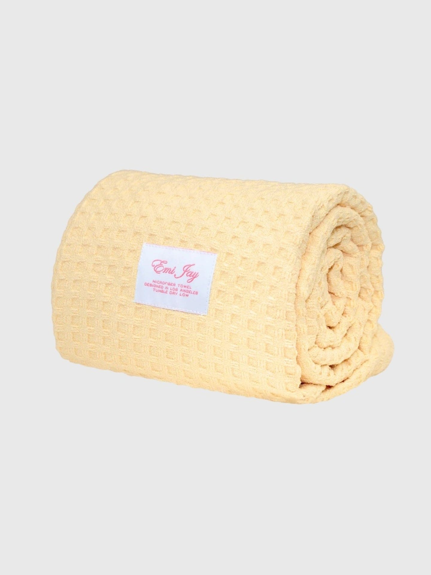 Rolled yellow microfiber towel with Emi Jay label, soft textured fabric for drying hair