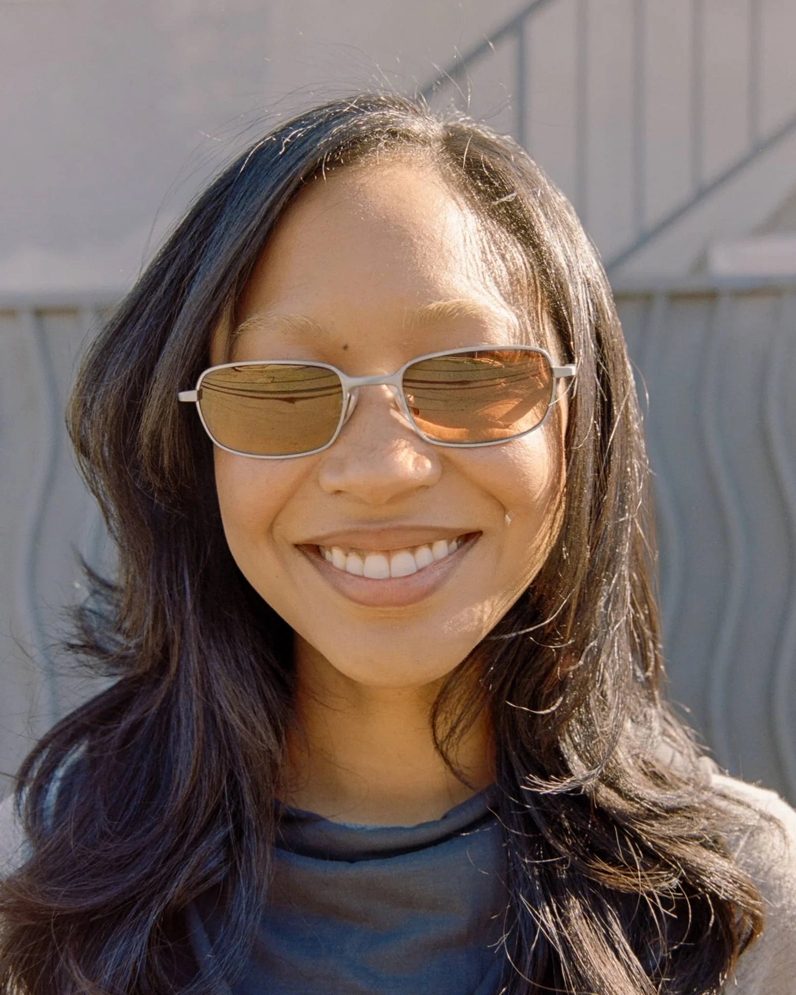 Woman wearing sunglasses with a neutral background