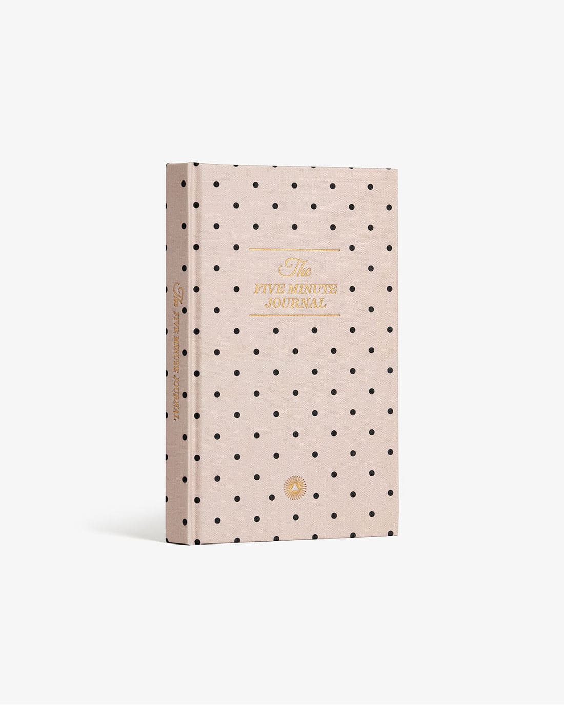 Pink polka dot hardcover journal with gold foil text reading "The Five Minute Journal" and decorative sun emblem