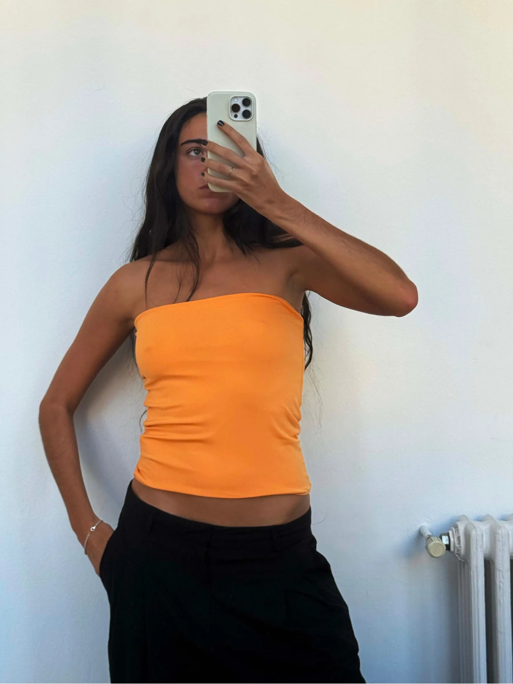 Orange strapless tube top paired with black pants, form-fitting stretch fabric, casual athletic wear style