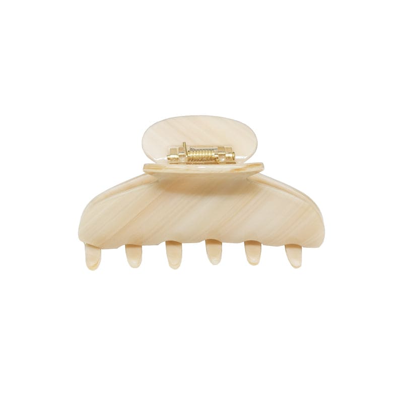 Cream-colored plastic hair claw clip with rounded top and six teeth, featuring gold-tone metal clasp mechanism
