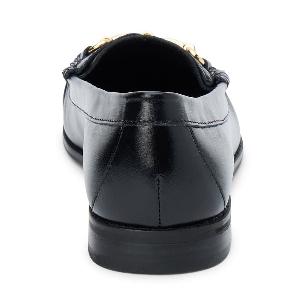 Black leather slip-on shoe with gold chain detail, rear view showing heel and sole construction