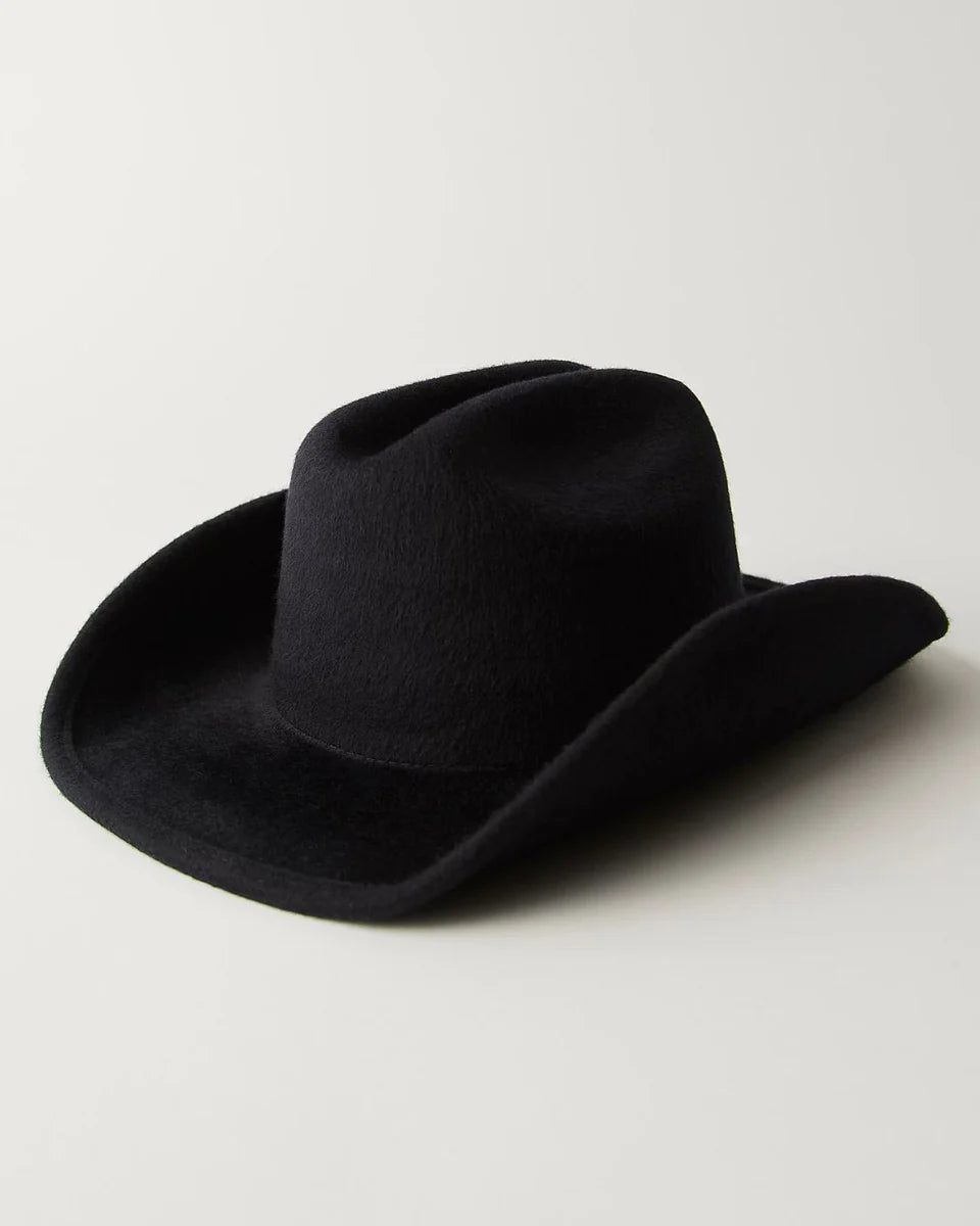 Black felt cowboy hat with wide brim and curved edges on neutral background