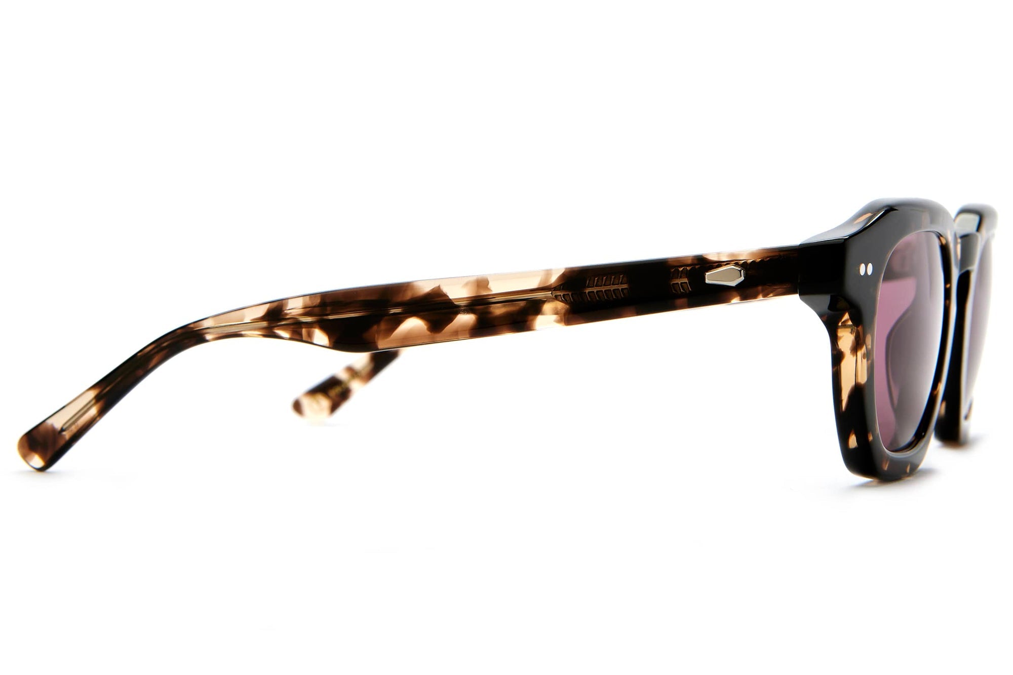 Tortoiseshell acetate sunglasses with dark lenses shown from side angle on white background