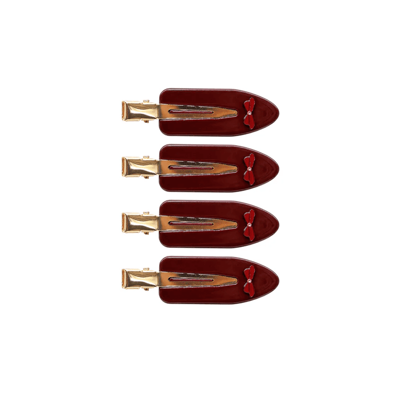 Four burgundy velvet hair clips with small red bows and gold metal clasps arranged vertically on white background