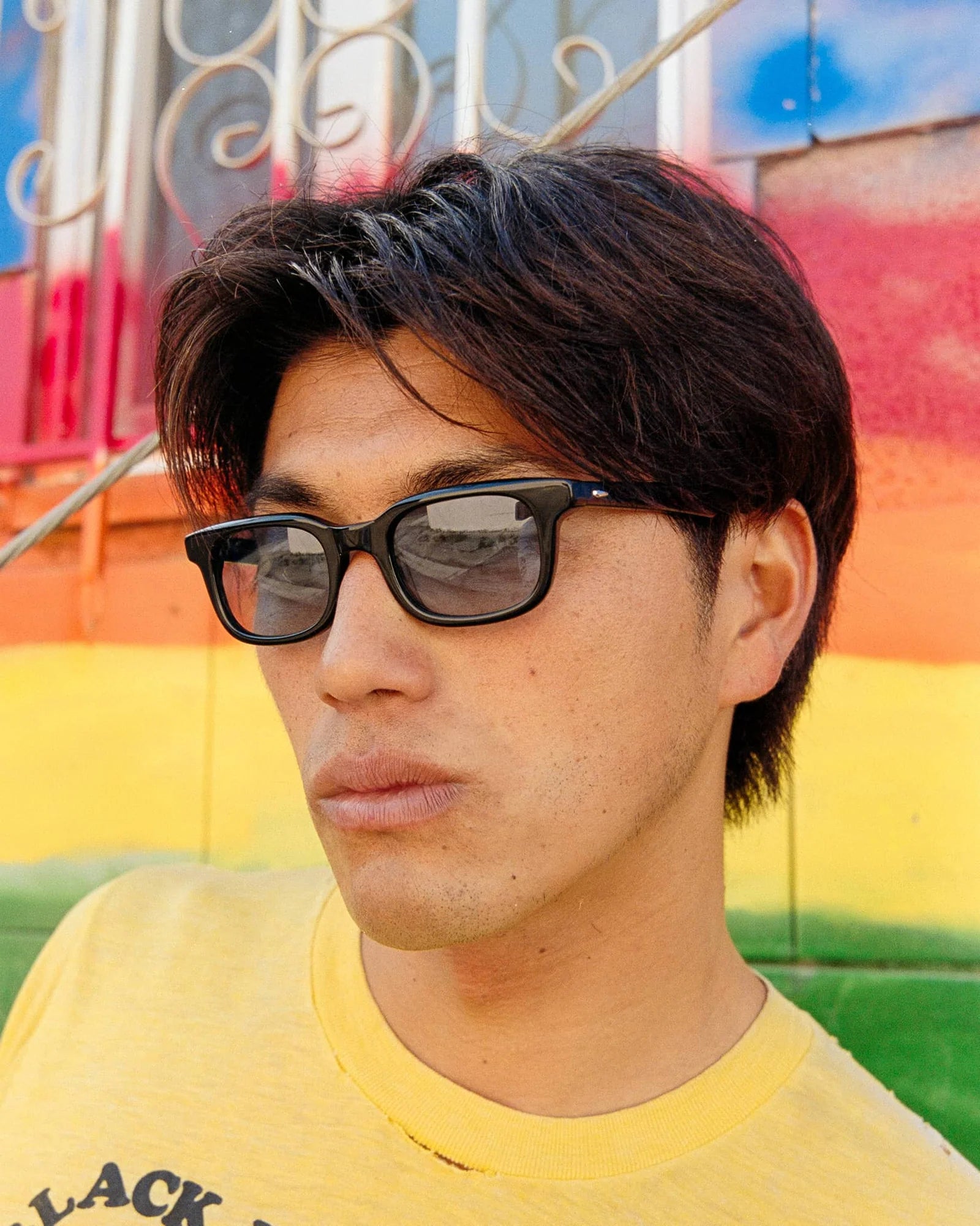 Person wearing sunglasses with a colorful background