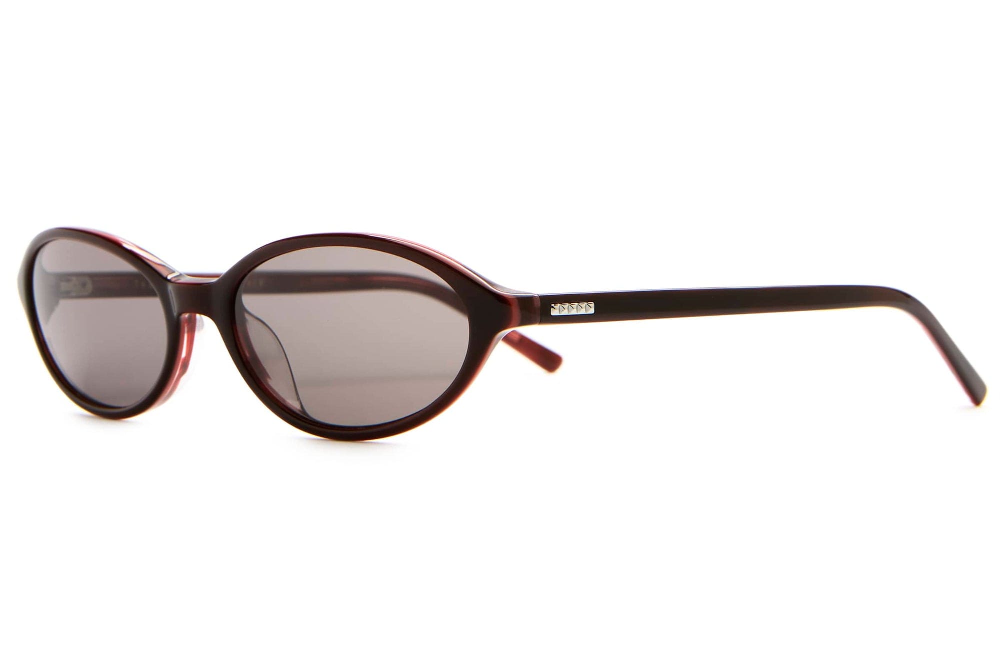 Oval brown tortoiseshell sunglasses with slim temples and gray tinted lenses on white background